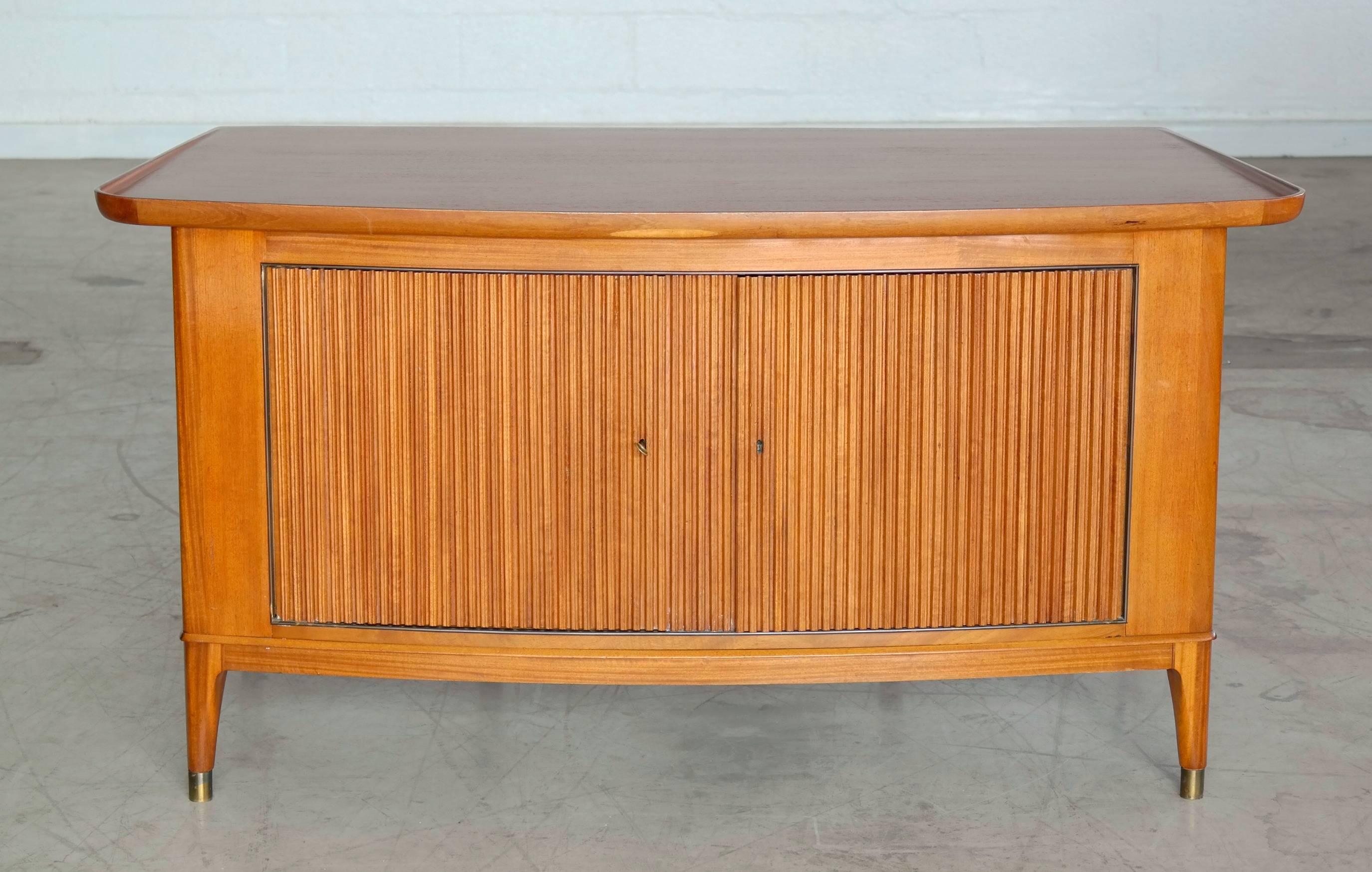 Superb quality 1930s Danish Art Deco period desk in pale Cuban mahogany with brass shoes. Beautifully made with rounded outer corners to give that true Art Deco flow to this quality desk. The front has two large lockable storage compartments behind