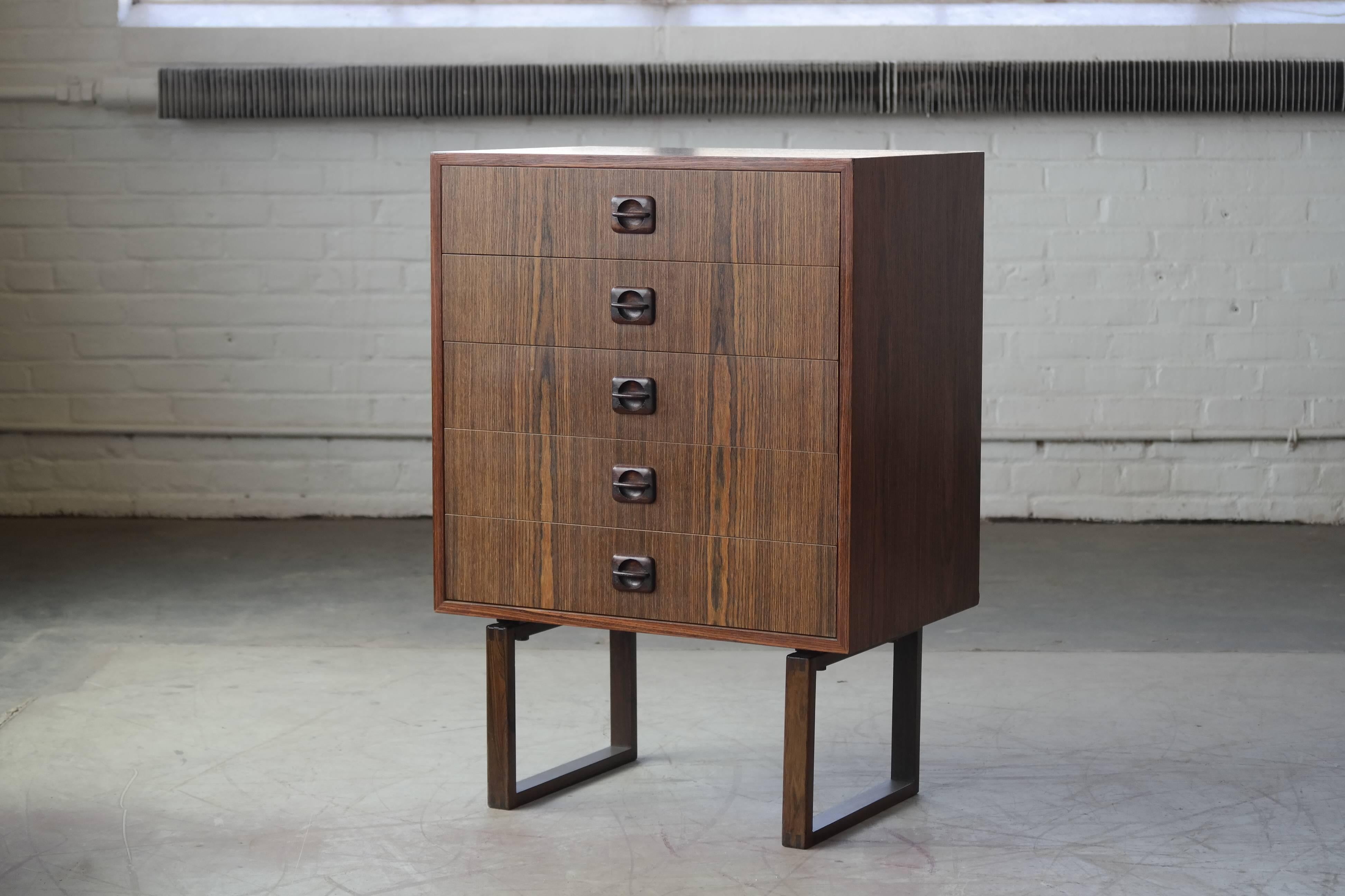 Very modern and beautiful medium size dresser. in rosewood with carved pulls in solid wood. 
Unknown designer and maker but definitely Danish and much in the style of Illum Wikkelsø or even Kai Kristiansen. We love the legs!
 