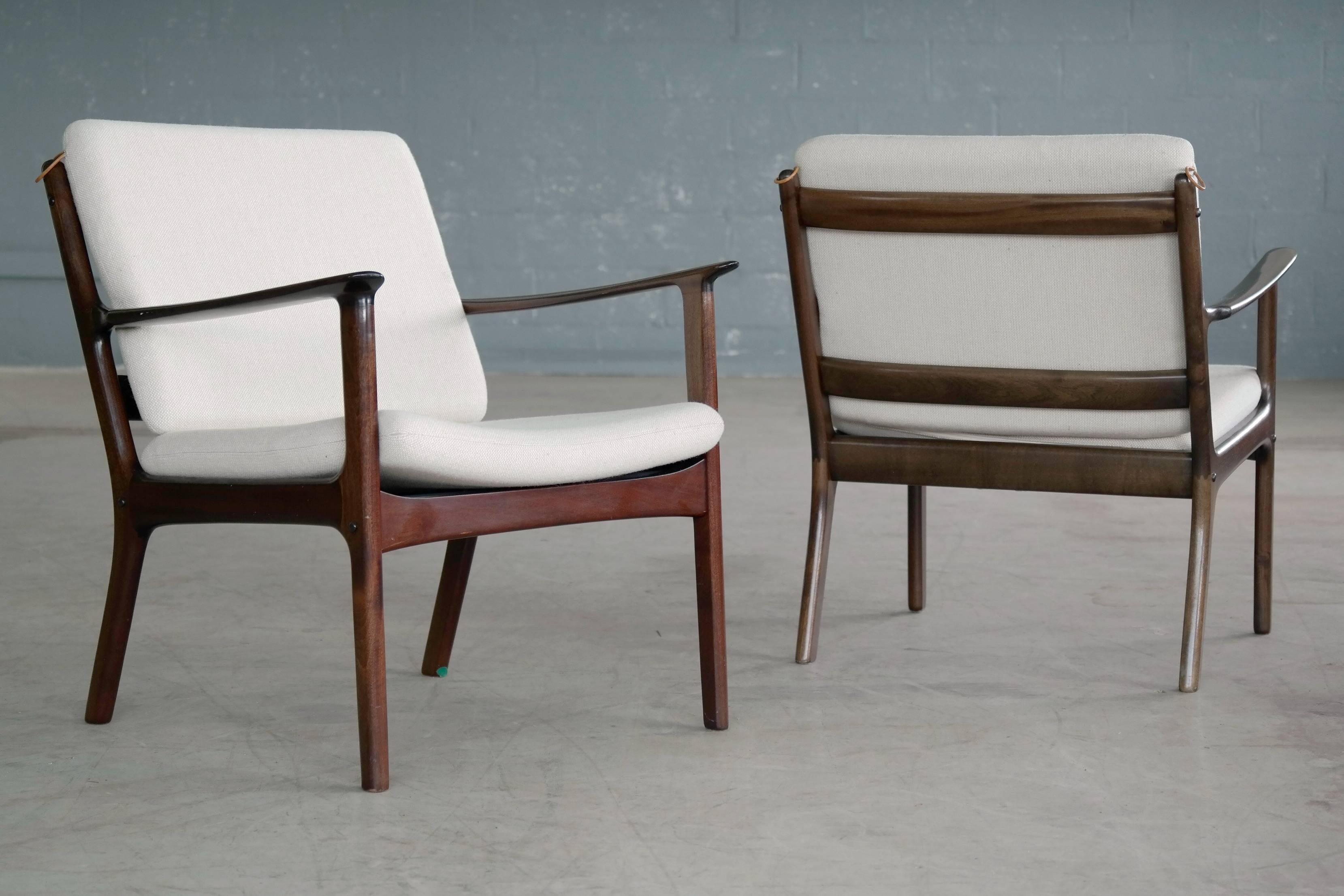 Classic Ole Wanscher design pair of easy chairs model PJ 112 designed in 1951 and produced P. Jeppesen Møbelfabrik. Marked accordingly model PJ 112 to the frame. The back has a bit of sun fading on the wood. White original wool cushions with leather