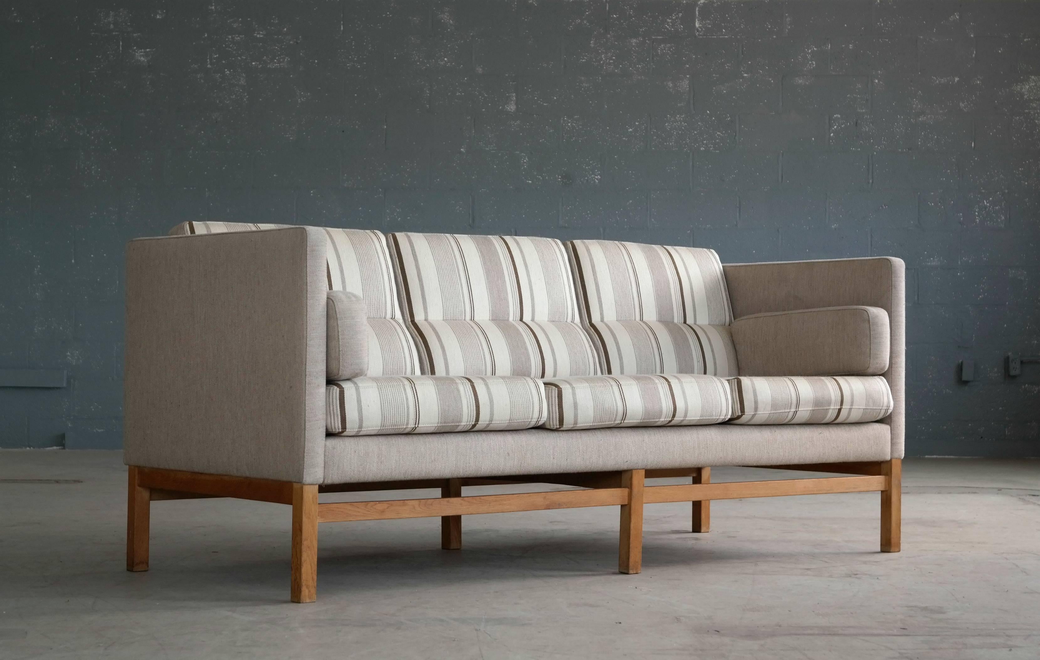 Very stylish Danish sofa in the style of Erik Jorgensen, 1975, equally straight-laced formal and playfully modern. High quality wool fabric and only very minor age appropriate wear. 
 