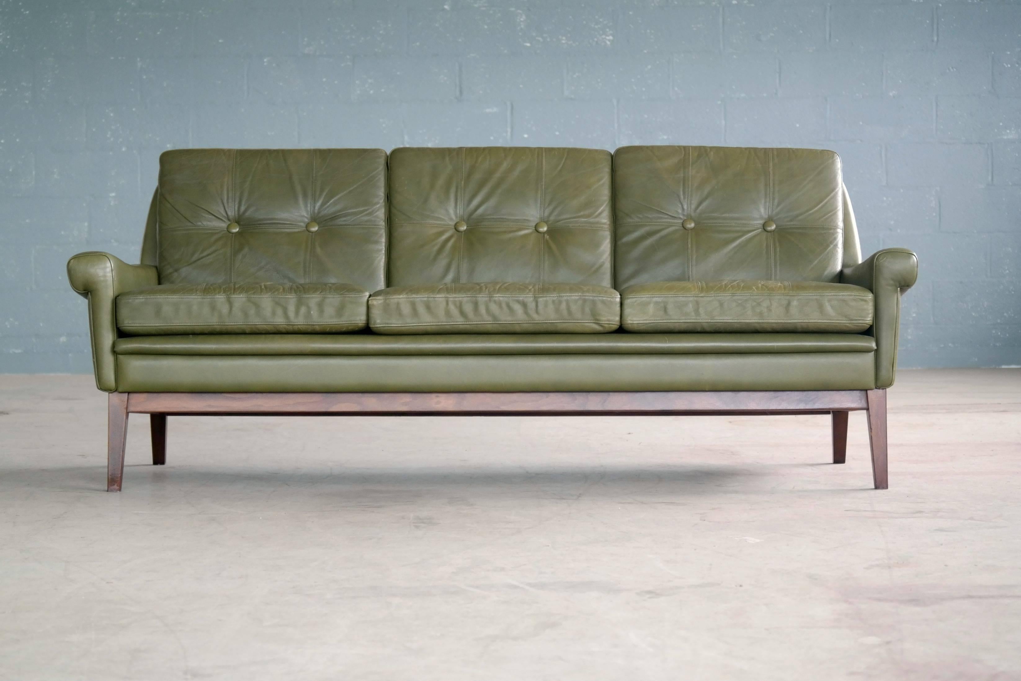 Elegant three-seat sofa by Svend Skipper made in the 1960s in a beautiful dark green color. Elegant iconic Skipper design with slender lines, with nicely shaped armrests and comfortable cushions. This model varies from similar Skipper designs in