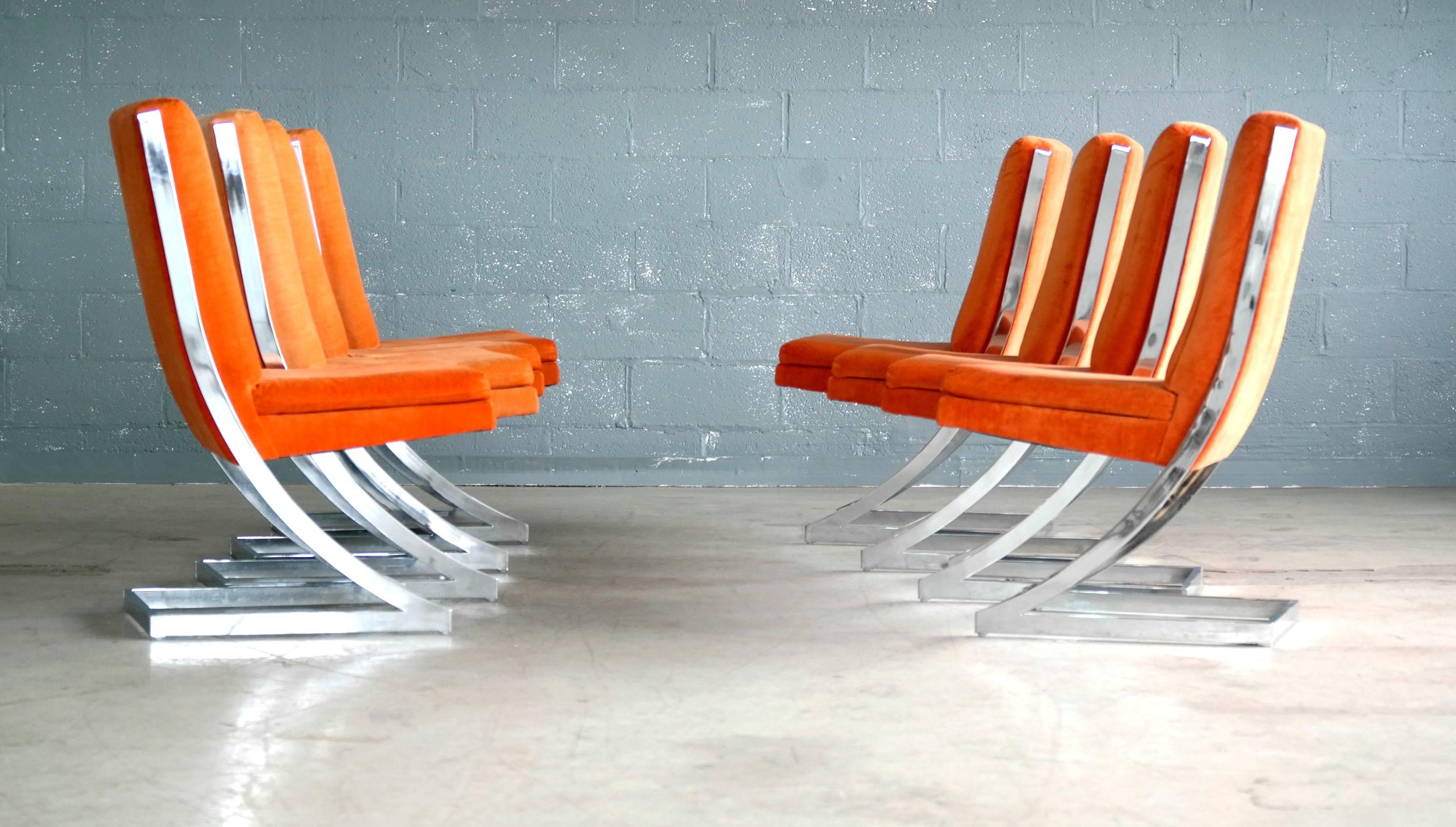 Fantastic set of eight cantilevered chrome dining chairs designed by Milo Baughman for Design Institute of America. Original fabric in vibrant orange shows wear consistent with age and some minor sun fading in a few places. Still very usable but