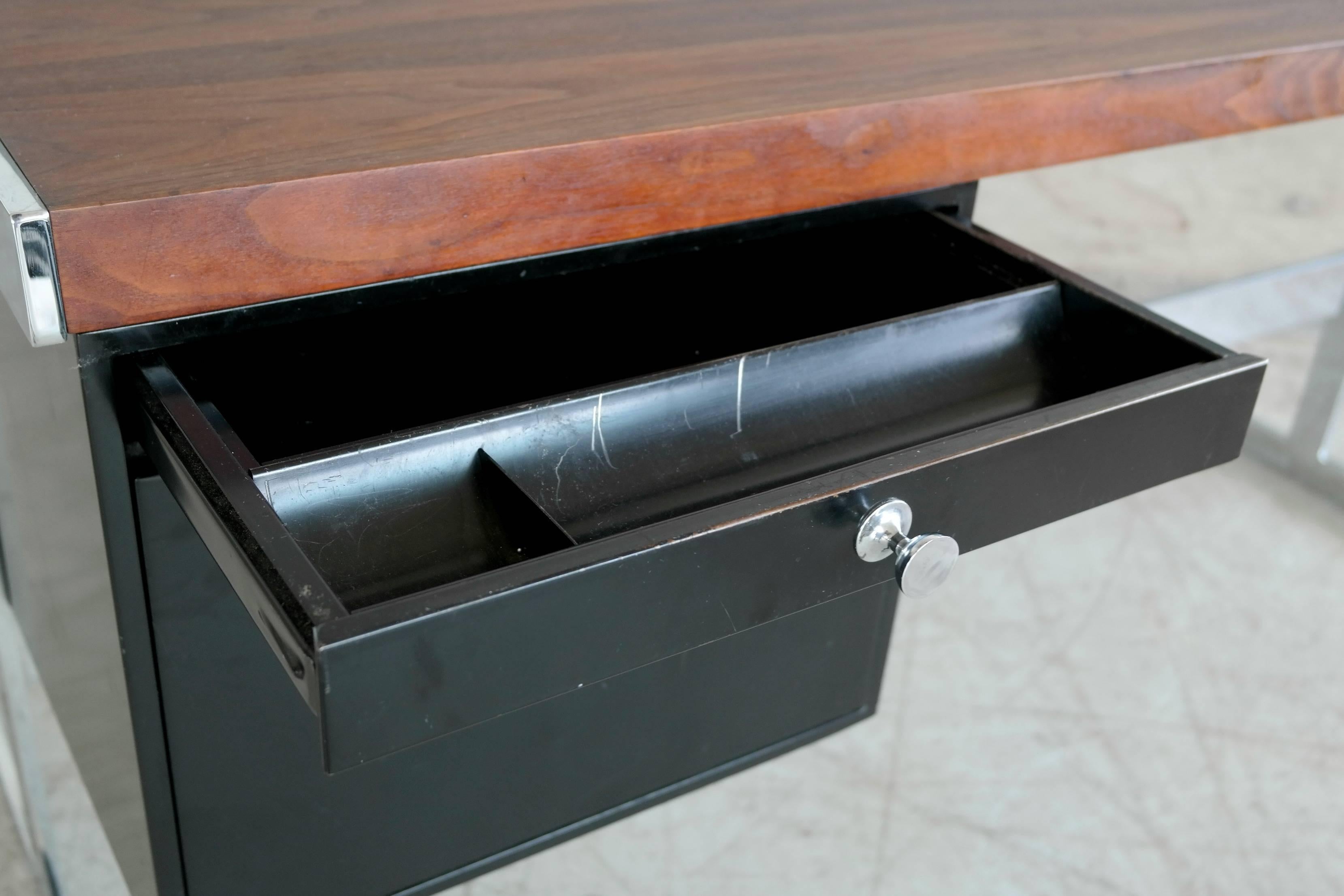 Sleek and super stylish desk with a rosewood top on a chrome base. Two black lacquered metal drawers to the left with one drawer for hanging file folders drawer and a file cabinet. The drawer section is removable. Unmarked but the table is often