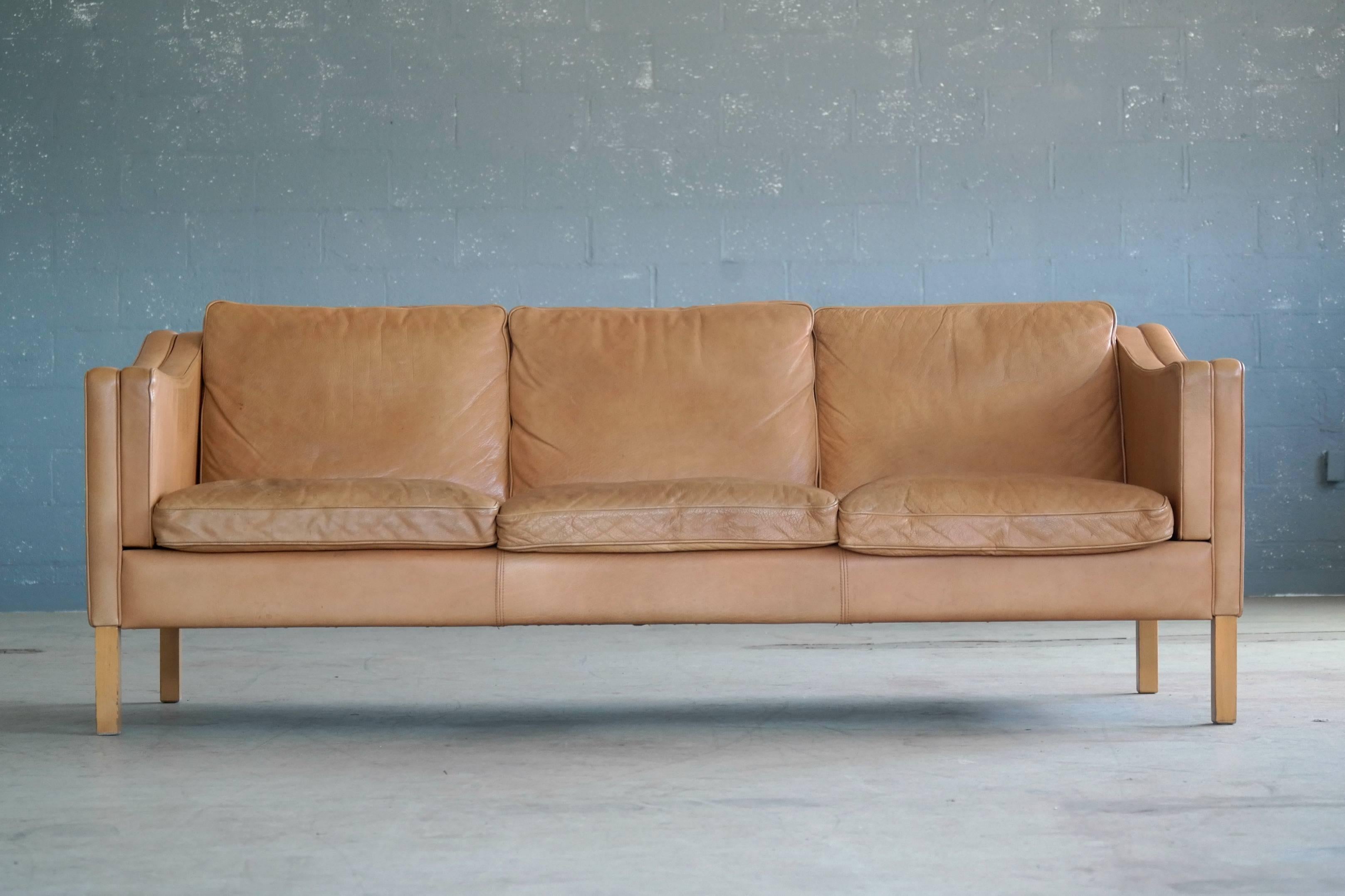 Classic Børge Mogensen model 2213 style sofa in tan leather by Stouby Mobler, circa 1970. Highest quality craftsmanship upholstered in aniline leather. Some sun fading of the color and just the right amount of patina and wear, scuffs and scratches