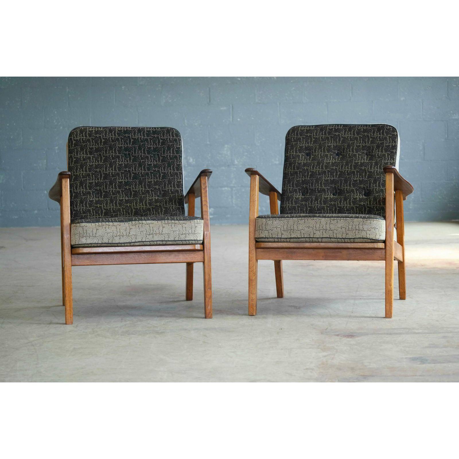 Very elegant high quality pair of Danish easy chairs from the 1950s in the style of Arne Vodder and Hans Wegner's Cigar chair. Solid oak bases with armrests in solid teak and a very nice wood grain and with the original spring loaded cushions.
