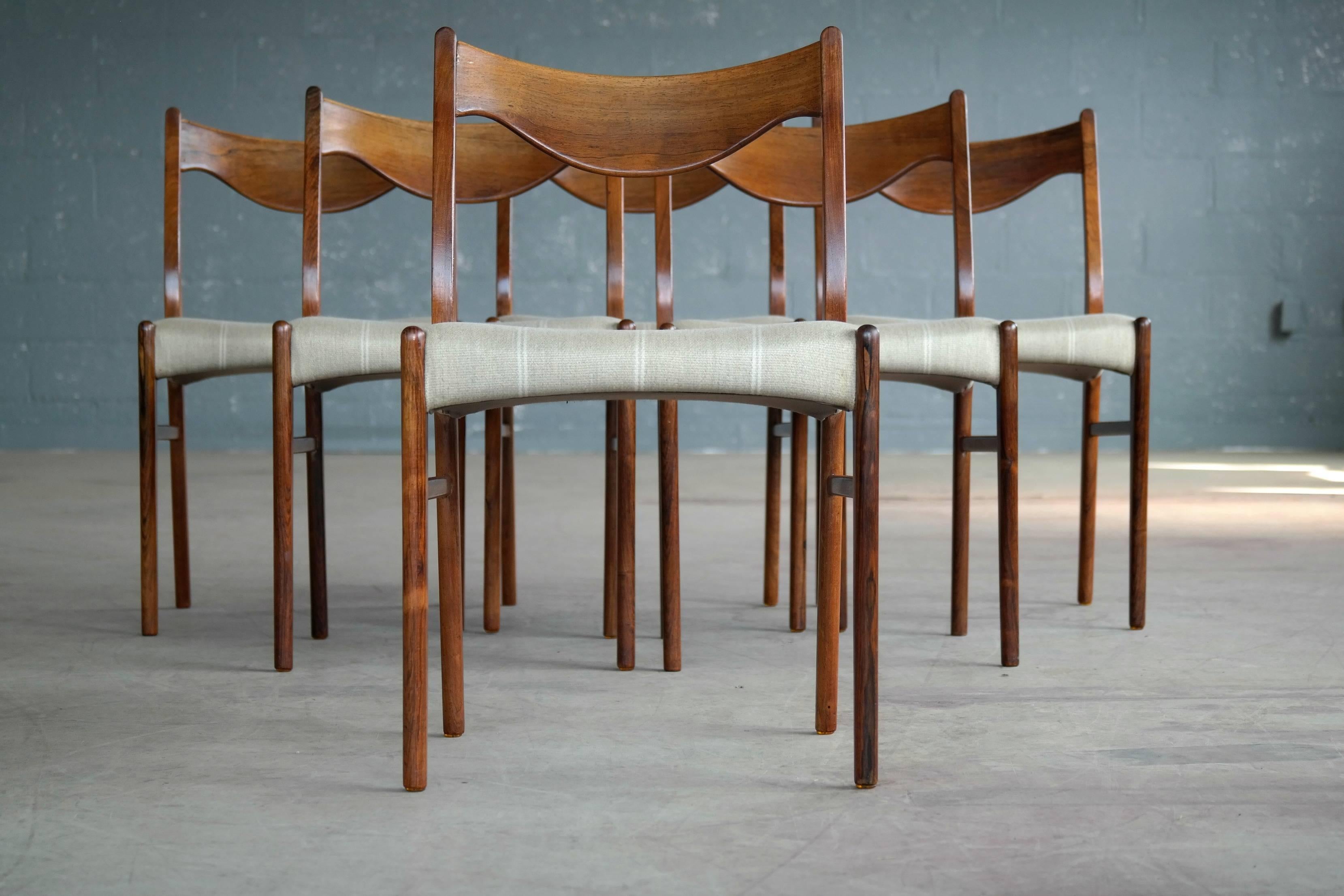 Very elegant and rare set of six wool covered rosewood dining chairs designed by Arne Wahl Iversen in the 1960 for Glyngøre Møbler. The beautiful, refined details such as the curved seat sides and sculptural backrest bear a certain resemblance to N.