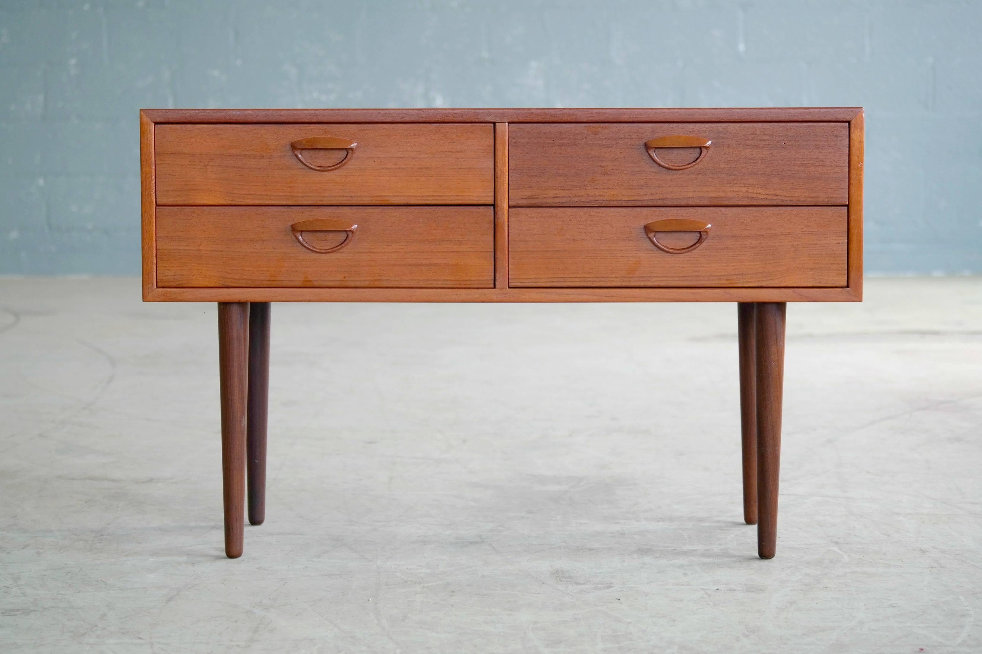 Superb small console or chest of drawers in teak designed by Kai Kristiansen, produced by Feldballes Møbelfabrik in the 1960s. Features four drawers with carved handles. Very versatile design with multiple uses. Overall excellent condition with very