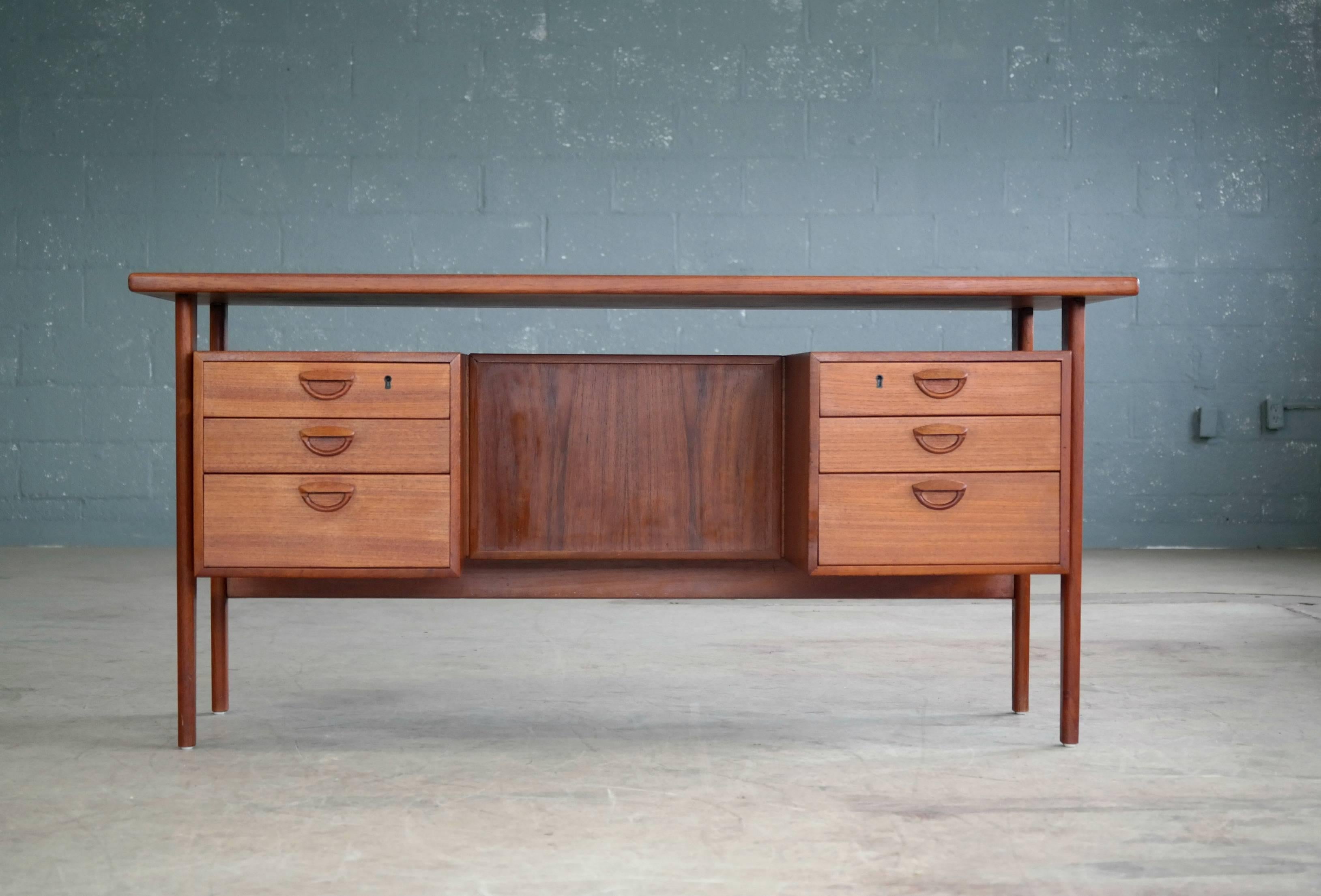 Beautiful Danish executive desk in teak designed in 1958 by Kai Kristiansen for Feldballe's Møbelfabrik as Model FM60. This freestanding desk features a floating top and six drawers in the front two of them lockable (key included) and three finished