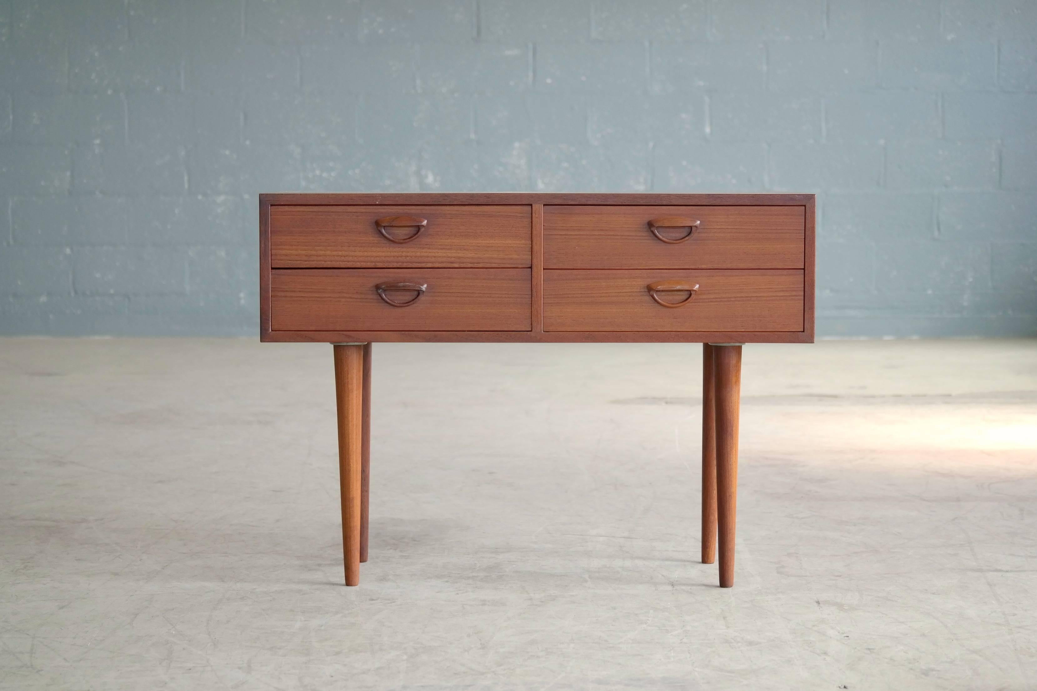 Beautiful chest of drawers or small console in teak from the early 1960s, designed by Kai Kristiansen for Feldballes Mobelfabrik in Denmark. This Danish chest of drawers is made of teak veneer and stands on solid teak conical legs. The drawer pulls