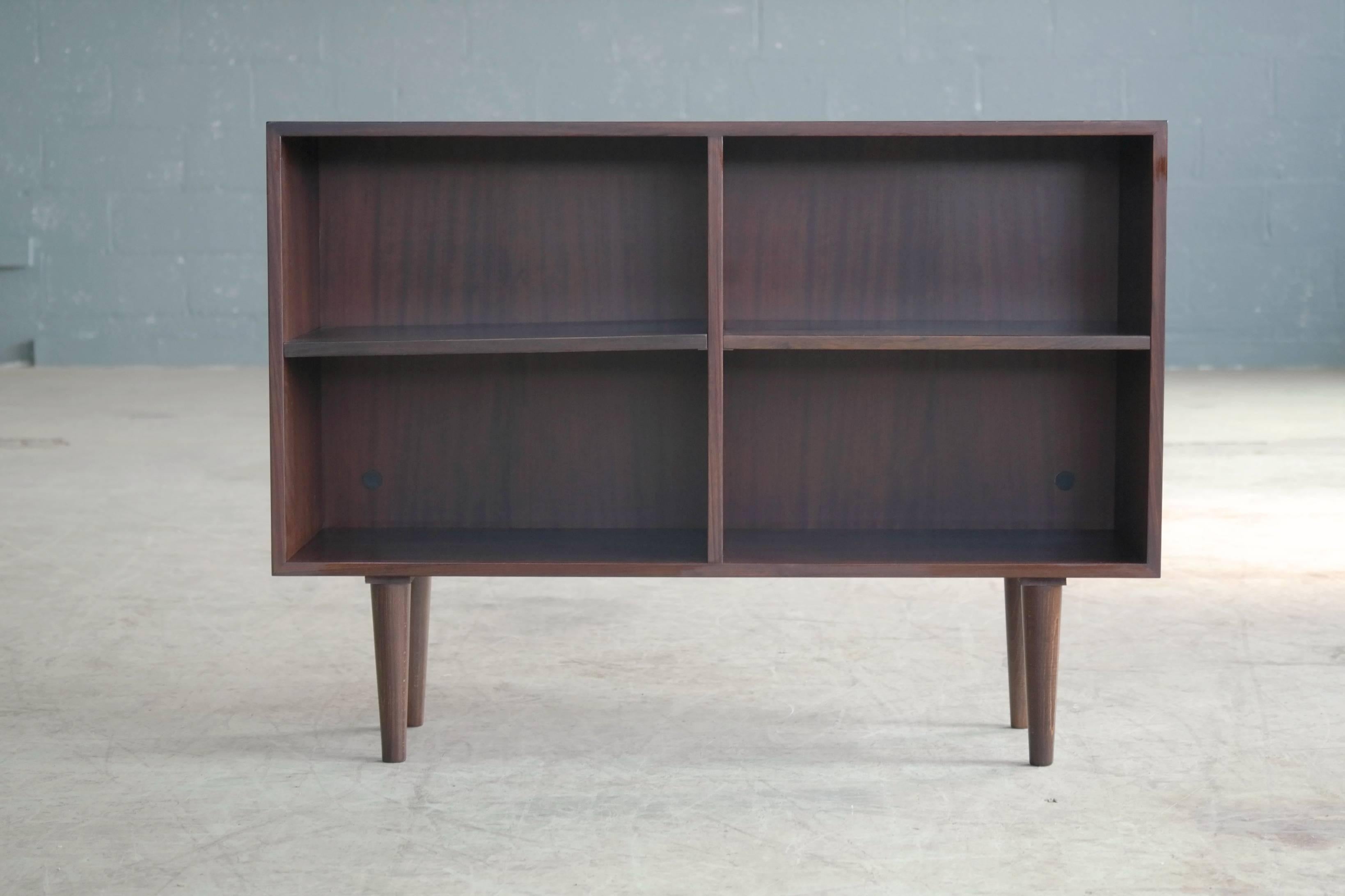 Very nice elegant rosewood bookcase in the style of Kai Kristiansen. Adjustable shelves. Very good condition with very minor age appropriate wear. We have a pair of matching bookcases without legs that are stackable with this one.