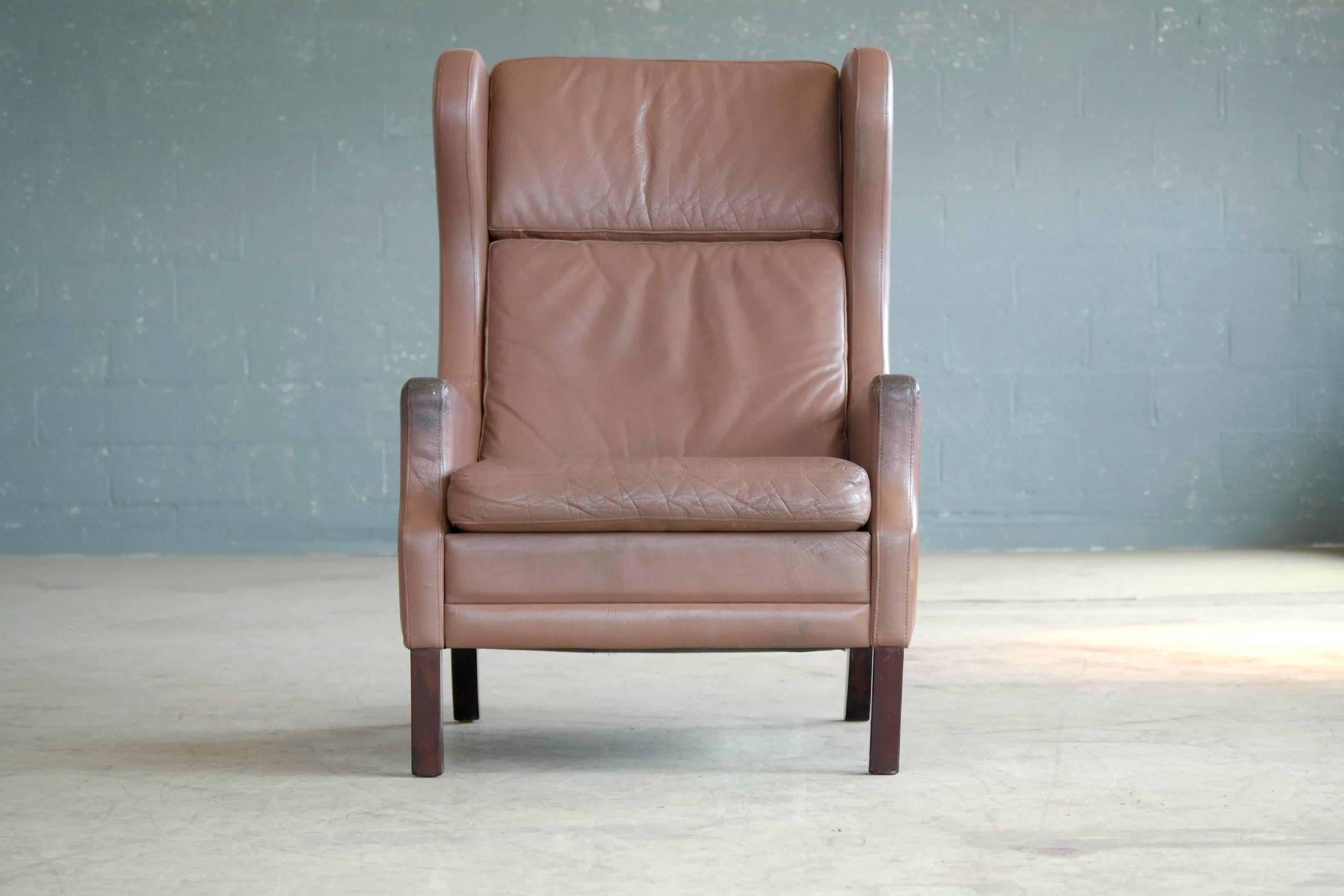 Georg Thams wingback chair in cappuccino colored leather. Made in the 1960s or early 1970s and very much in the style of Borge Mogensen. Great patina and age wear to the leather adding charm and character. Overall very good condition.