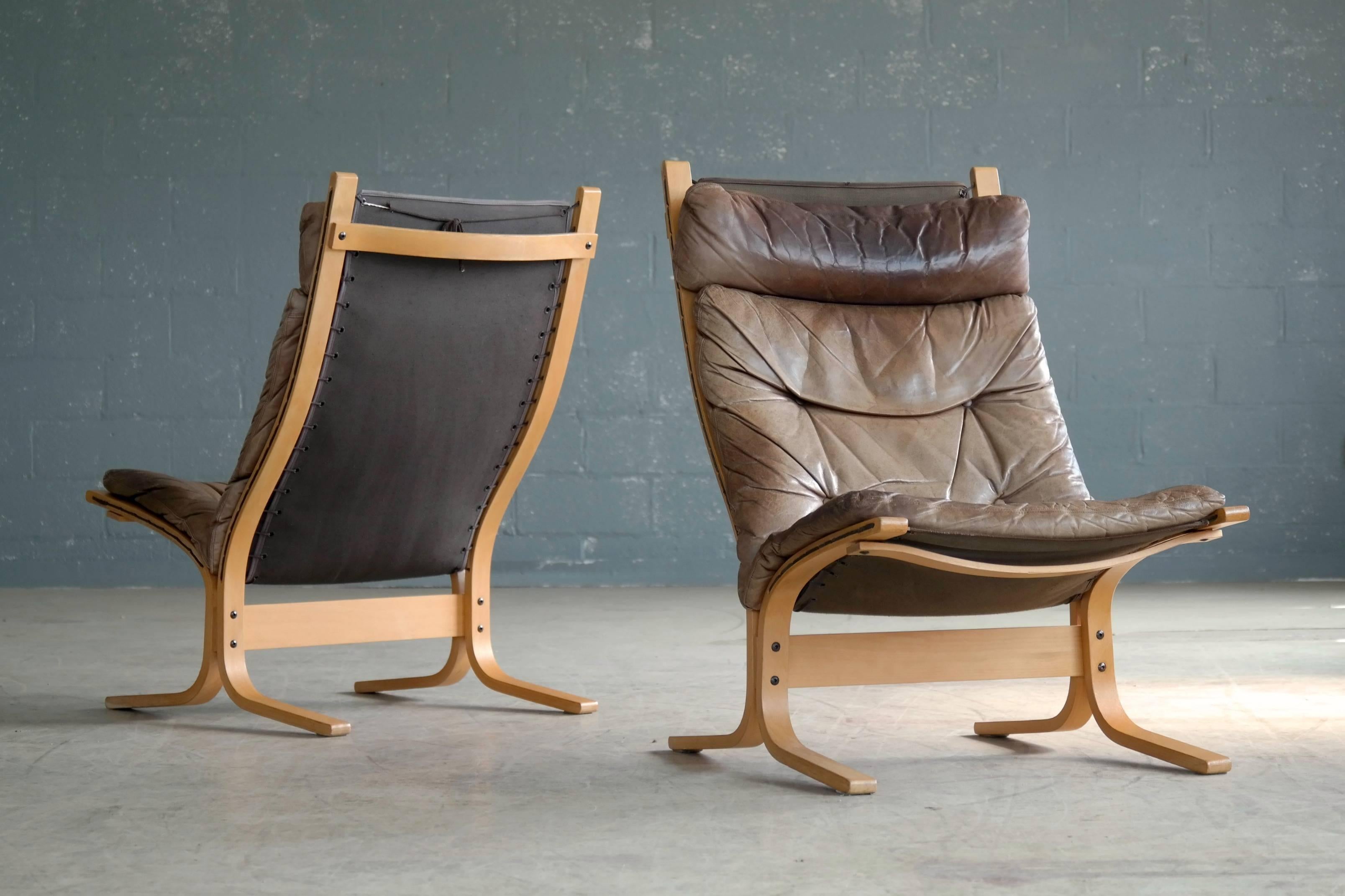 Great pair of Siesta chairs and one matching ottoman in patinated brown leather with bentwood frames in beech. Made of top grain leather that has obtained a very nice patina over the years and some minor soiling. Age appropriate scuffs and scratches