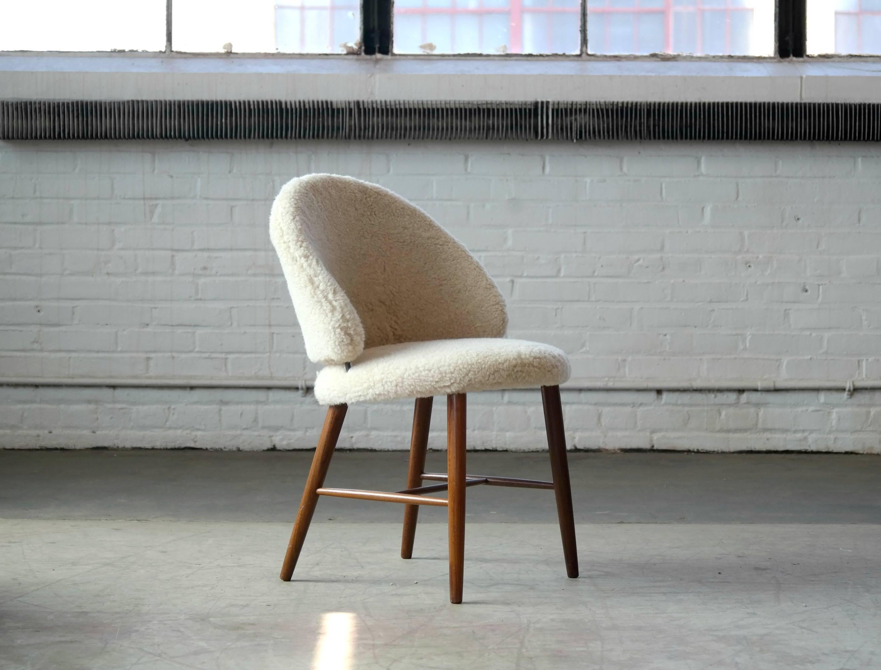 Wonderful vanity of dressing chair for the bedroom designed by Frode Holm in the 1950s for the high end retailer Illum's in Copenhagen. The chair has a round seat with the curved backrest elevated from the seat by brass spacers. The solid teak legs