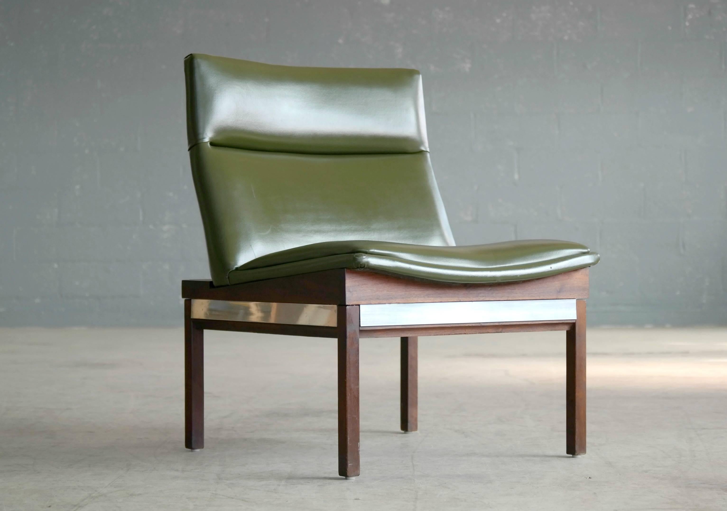 Very cool lounge chair in walnut with aluminum accents and covered in green Naugahyde designed by Arthur Umanoff in the 1950s for Madison Furniture Industries. Overall very good condition with just with minor natural age wear. 

The chair was part