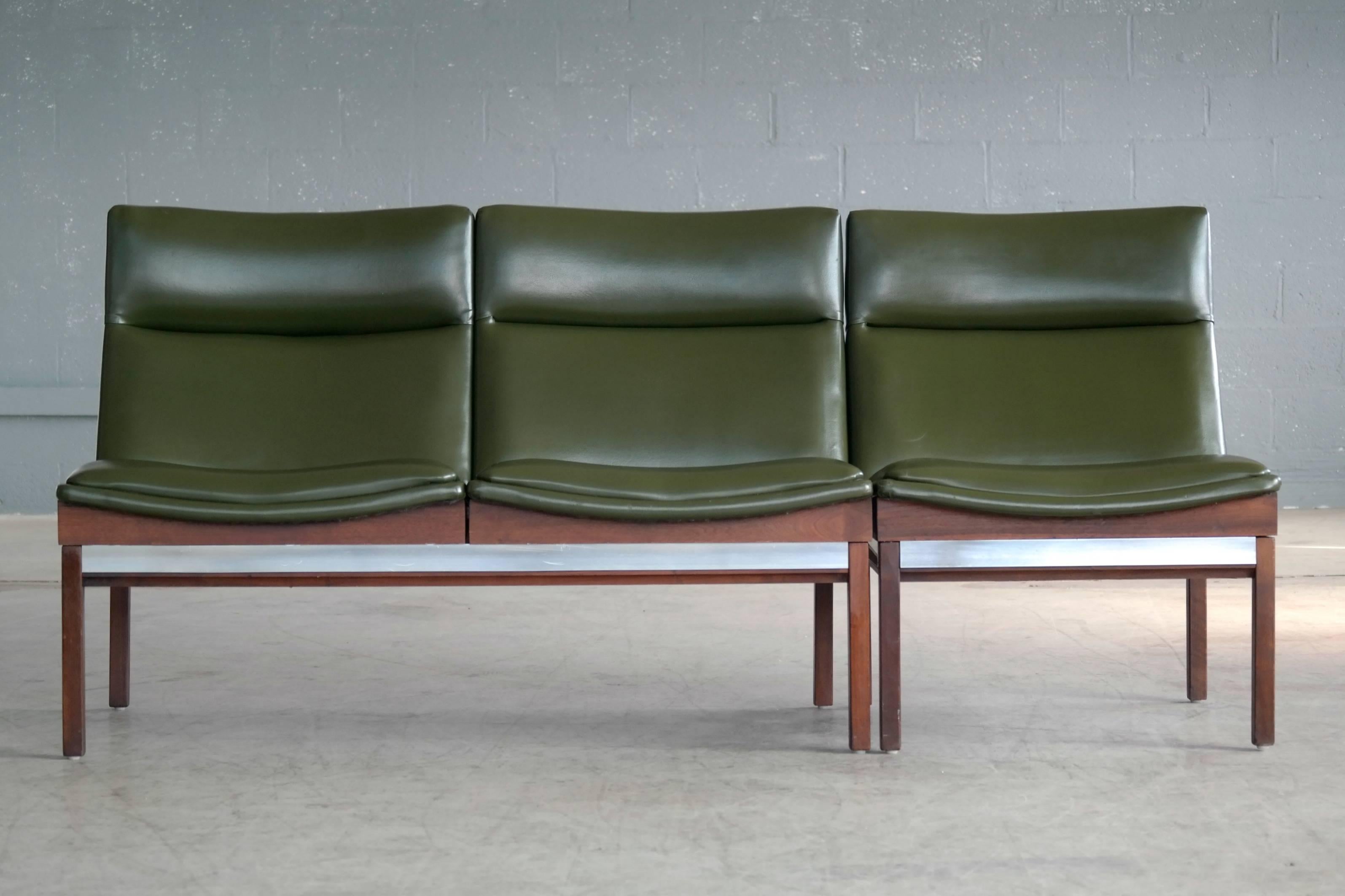 Ultra cool modular two-seat sofa and lounge chair in walnut with aluminum accents and covered in green Naugahyde designed by Arthur Umanoff in the 1950s for Madison Furniture Industries. Overall very good condition with a few small blemishes to the