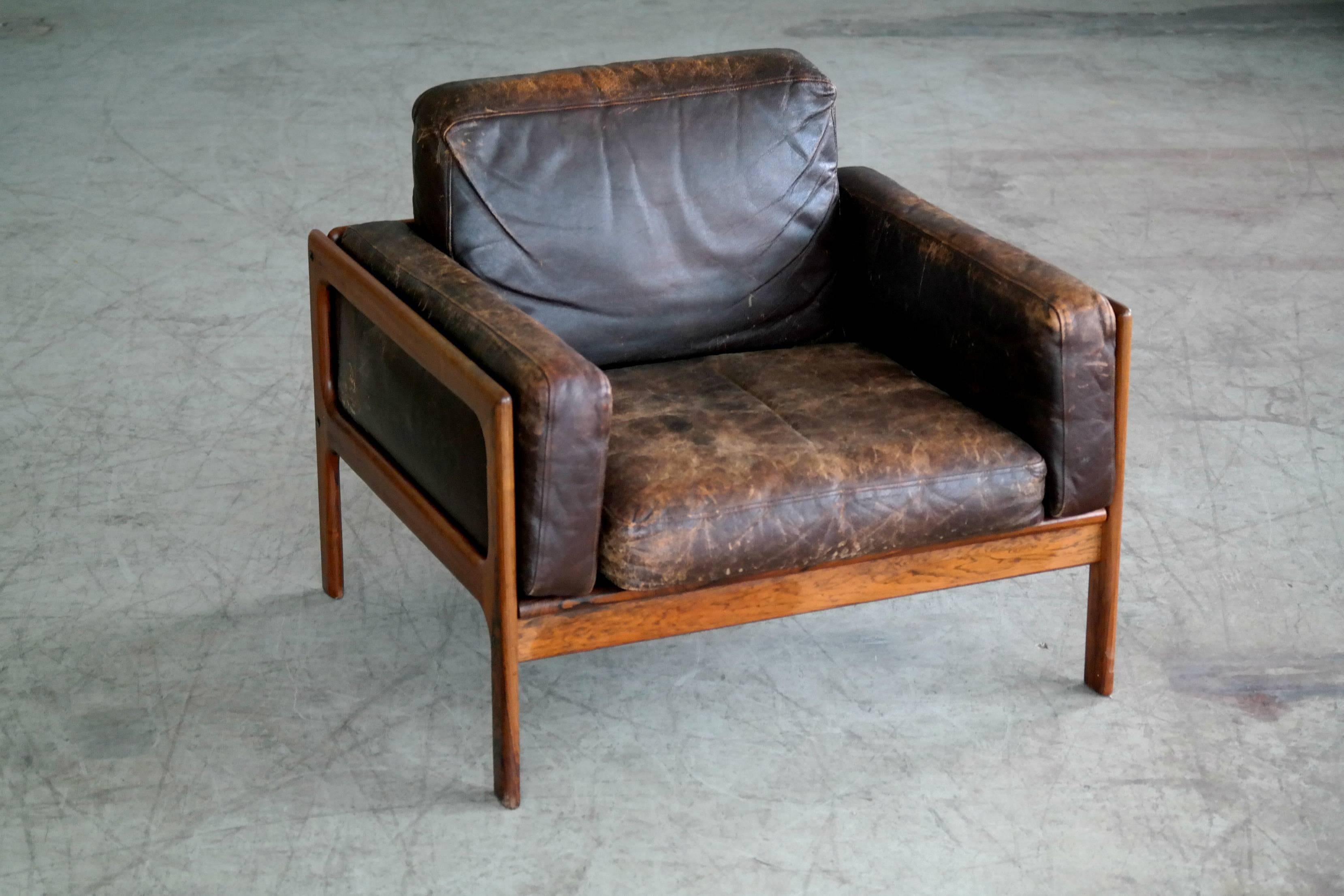 Fantastic and rare pair of easy chairs designed by Arne Wahl Iversen for Komfort Mobler of Denmark in the 1960s. Chocolate brown patinated leather with just perfect age wear on frames of Brazilian rosewood. The wood is in excellent condition with