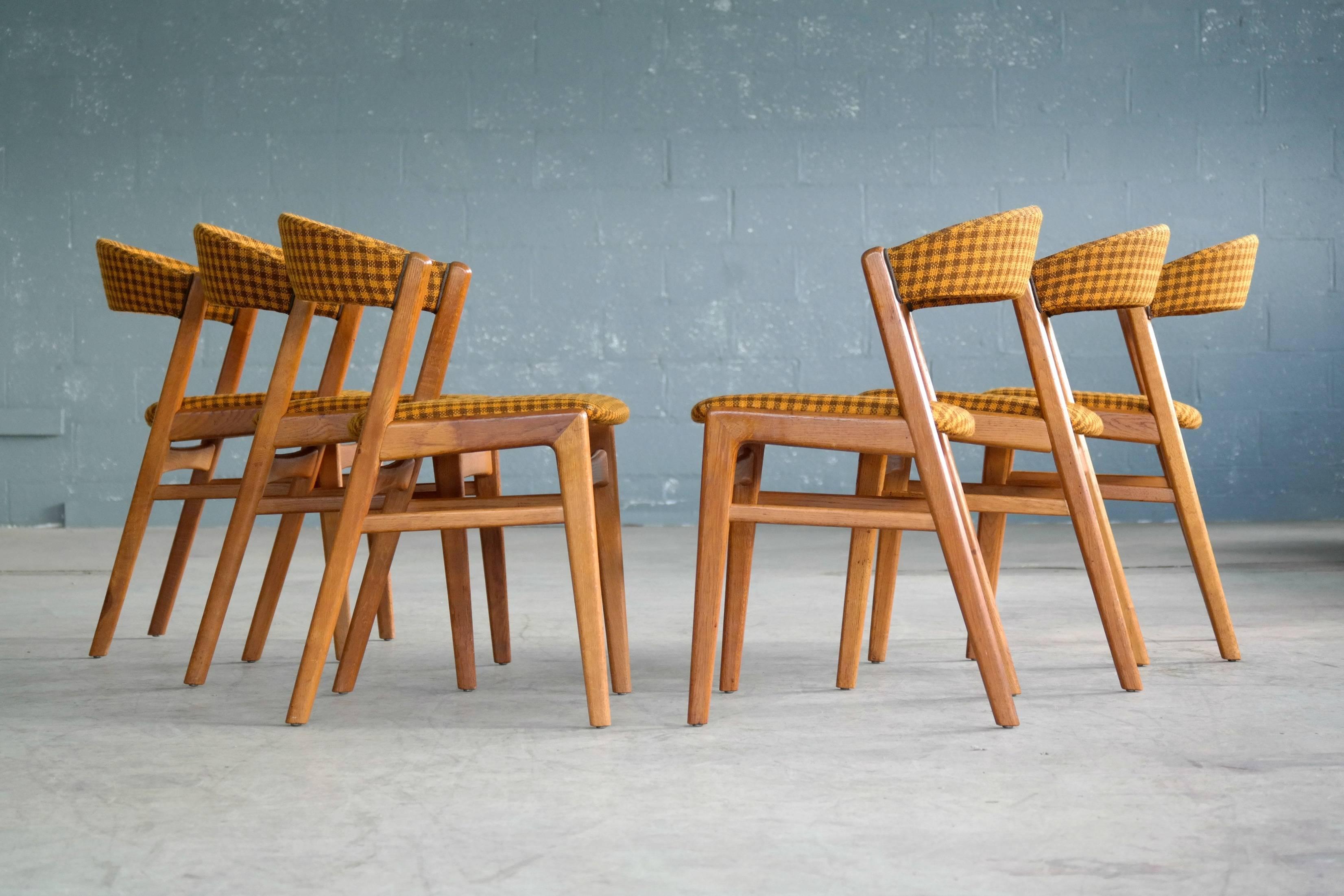 Very attractive set of six dining chair in oak with their original wool upholstery. This elegant set is very much in the style of some of the designs that Kai Kristiansen made for Korup Stolefabrik and also bears resemblance to Gunni Omann's