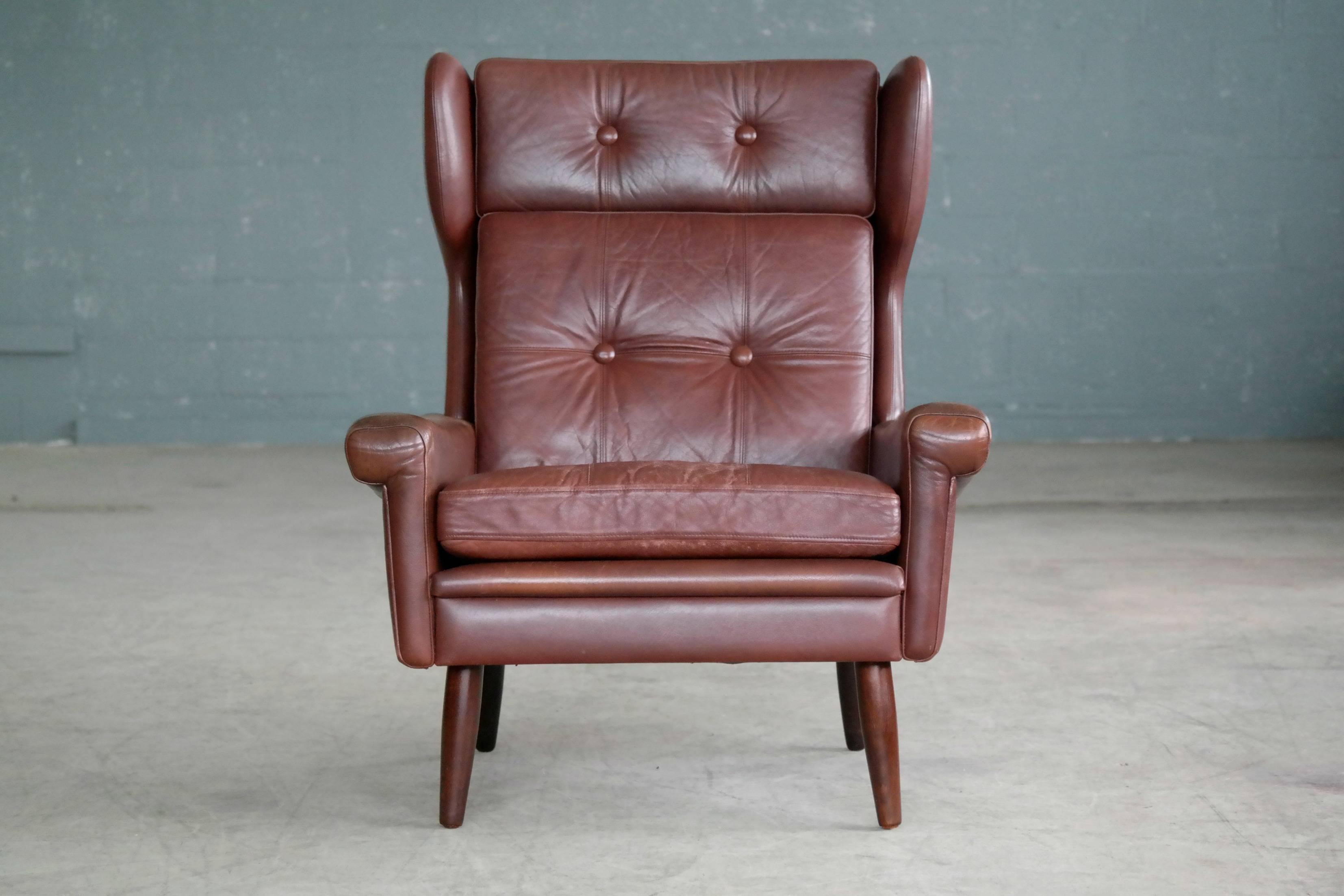 Very elegant winged high back leather armchair designed and manufactured by Sven Skipper in Denmark the 1960's. This Classic Skipper design is probably one of the best modern takes on a wingback chair ever made. Nice supple leather with lots of