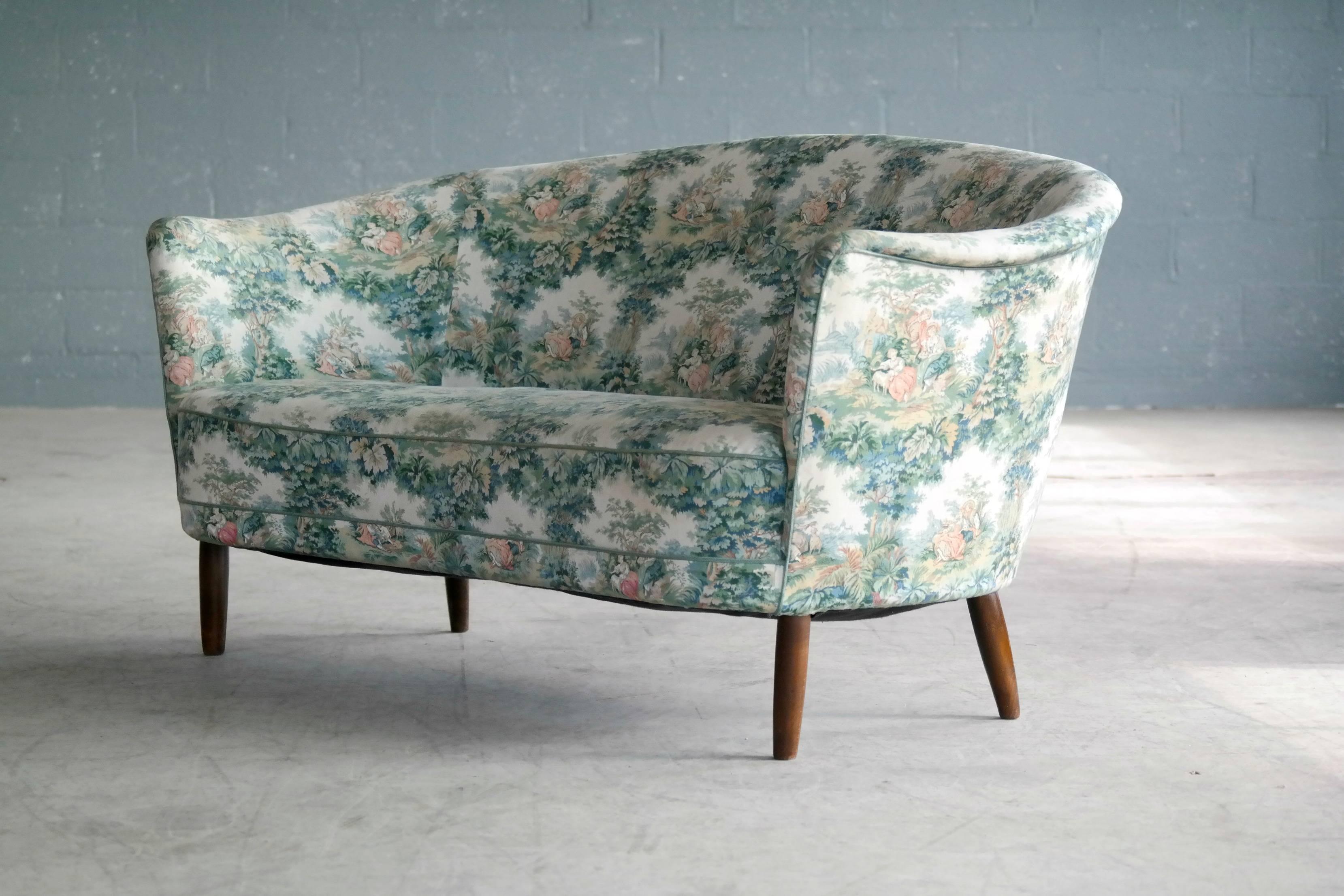 Beautiful and rare Carl Malmsten loveseat or small sofa. Carl Malmsten was a strong proponent of traditional Swedish craftsmanship expressed in very elegant lines and easily recognizable designs exemplified by the rolled-over armrests which is