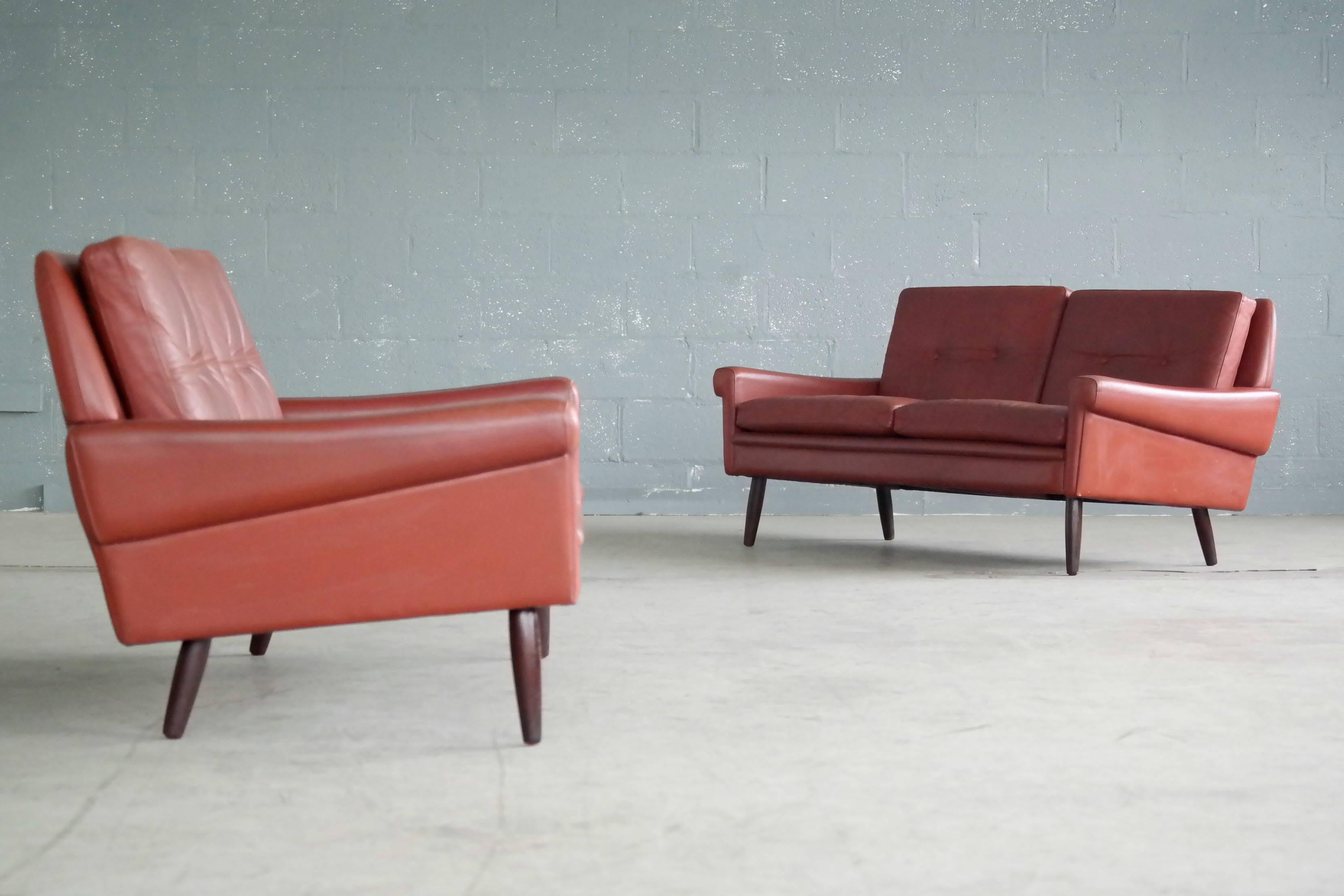 Wonderful loveseat or two-seat sofa designed by Sven Skipper in the 1960s. With loose cushions upholstered in buttoned reddish brown colored leather raised on stained beech legs. Overall very good condition with some natural age wear and patina