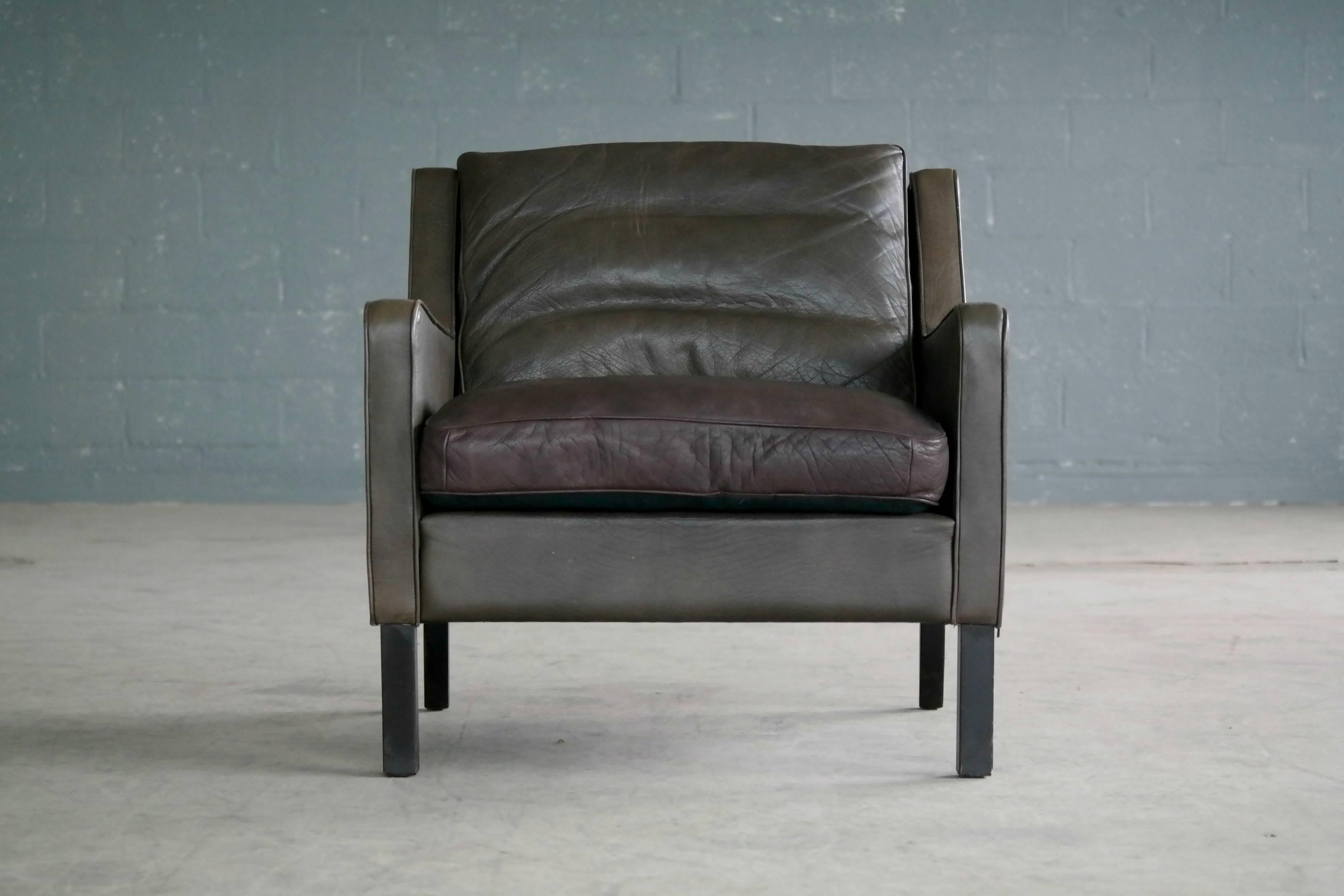 Classic Borge Mogensen style low back lounge chair in dark olive colored leather designed by Georg Thams for Vejen Polstermobelfabrik, Denmark. Very nice quality leather with great patina and age wear including a little bit of color fading on the