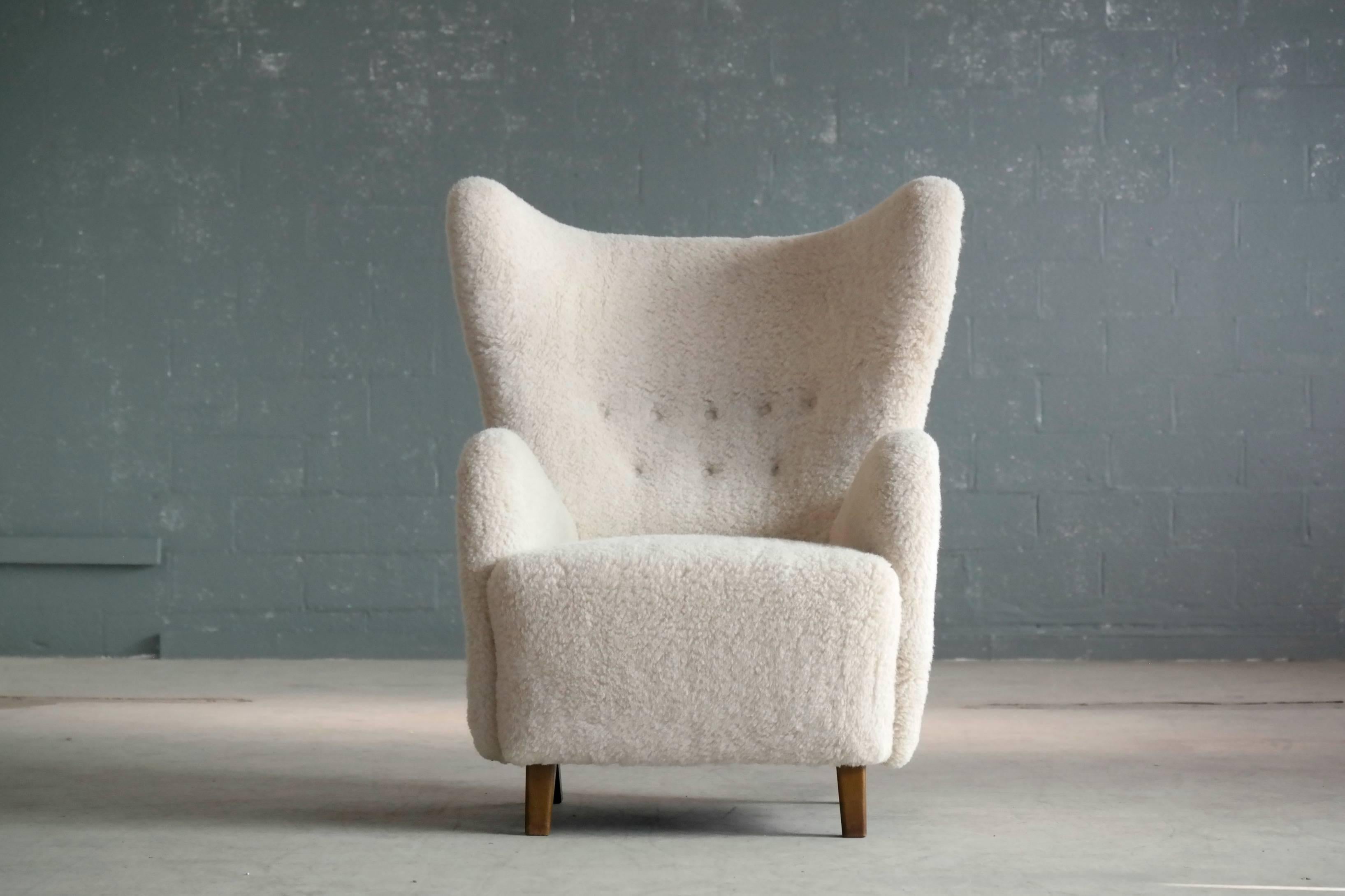Beautiful Flemming Lassen attributed high back lounge chair in lamb’s wool made circa 1940s. This iconic ultra-elegant lounge chair is probably one of the most perfect high backs ever designed. Perfect statement piece yet very comfortable.

The