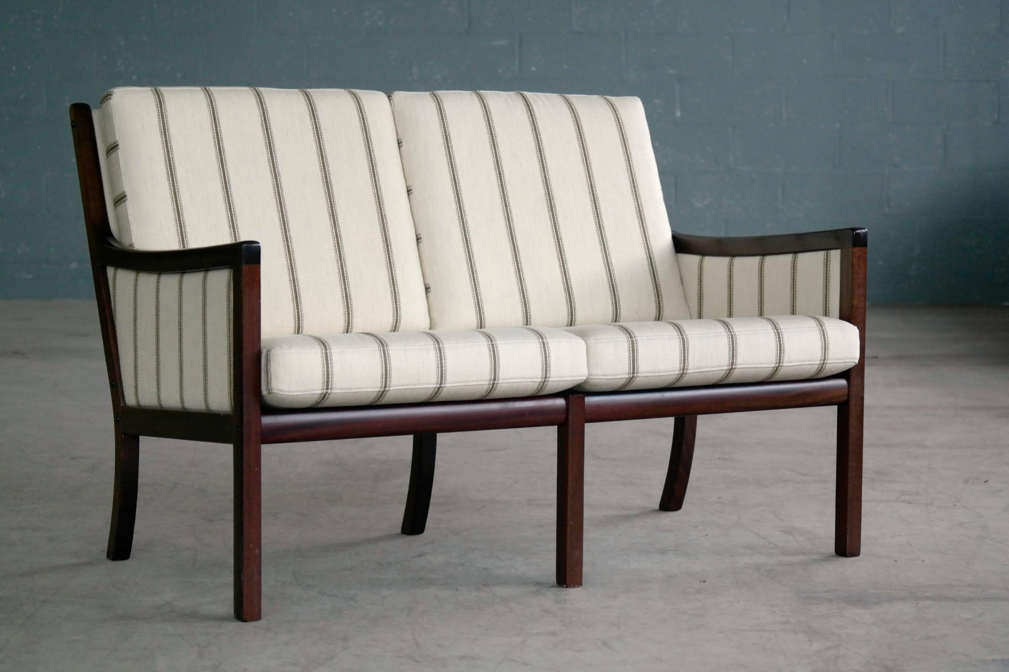 Classic and very elegant settee by Ole Wanscher designed in the 1950s and produced by P. Jeppesen Møbelfabrik likely sometime, circa 1970. Made from lacquered solid mahogany and covered in the original white wool with dark stripes. Nice deep dark