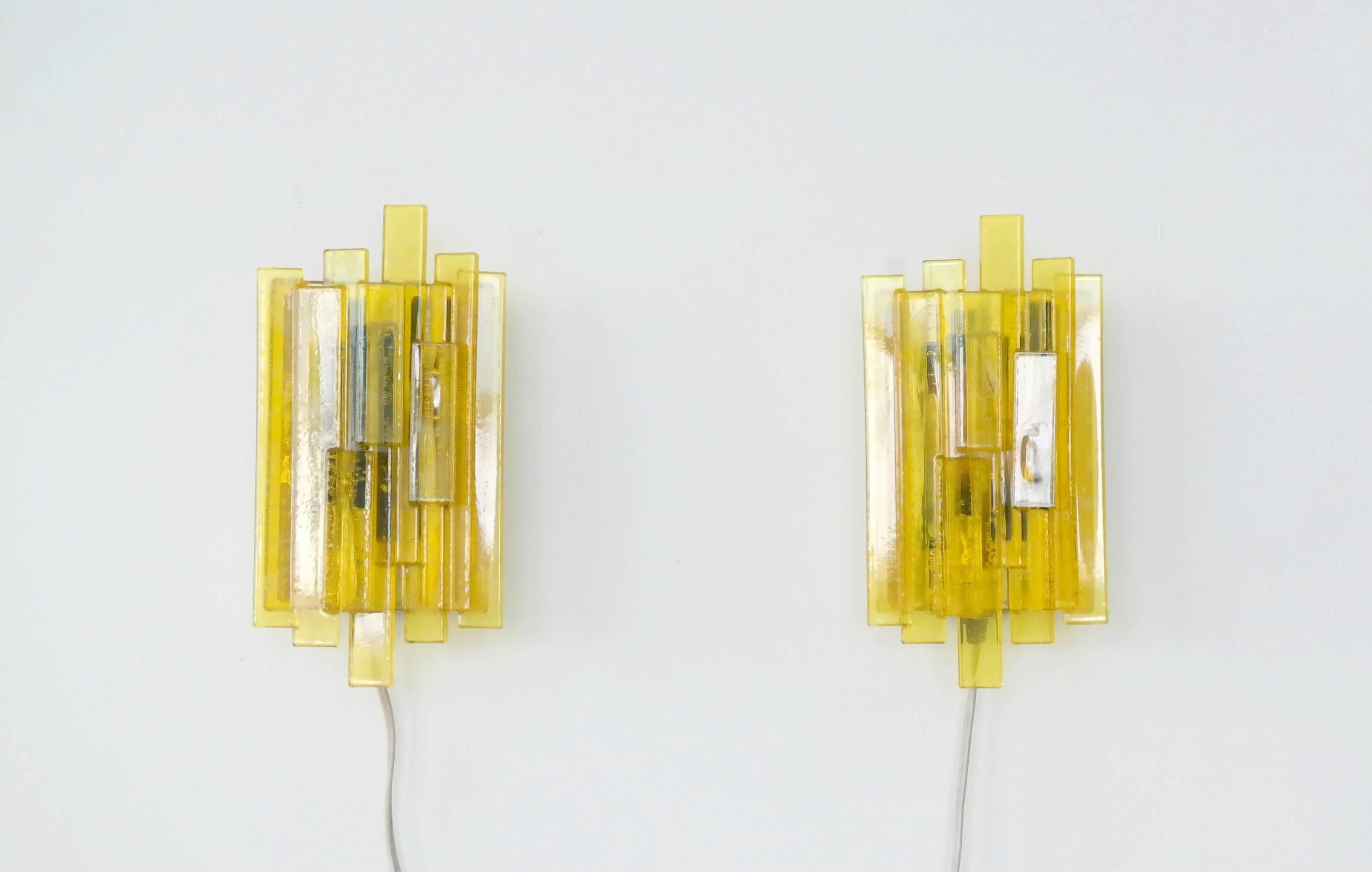 Very attractive pair of Space Age geometric wall sconces by Danish designer Claus Bolby. Made circa 1970 from yellow acrylic resin of different shapes and sizes on top of green acrylic in the center. Excellent condition.
 
