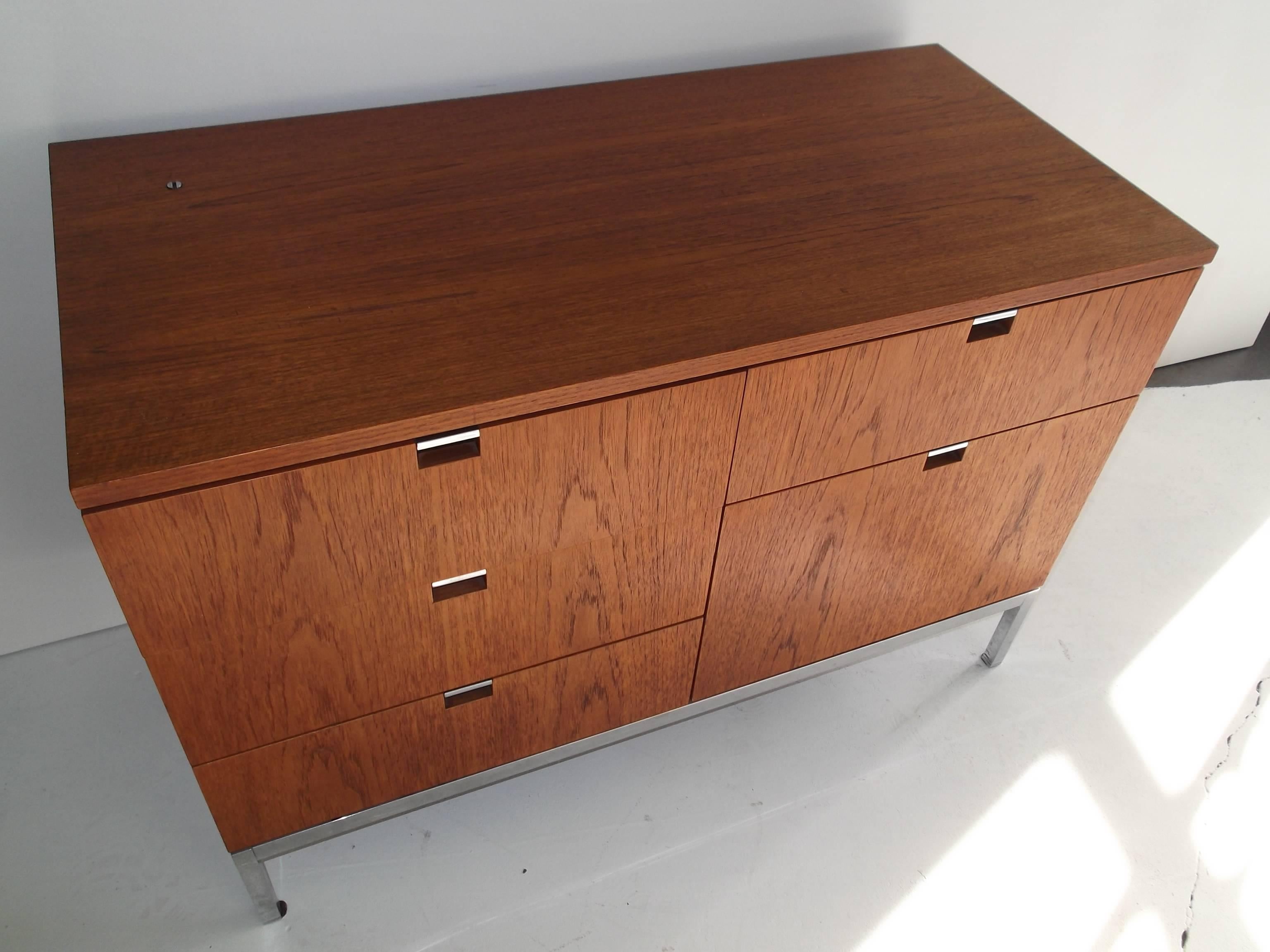 This is a small size five-drawer storage credenza. It is unusual to find them in teak. For its size, it weighs a ton. It retains partial 1970s era label to bottom. Top drawers have dividers.