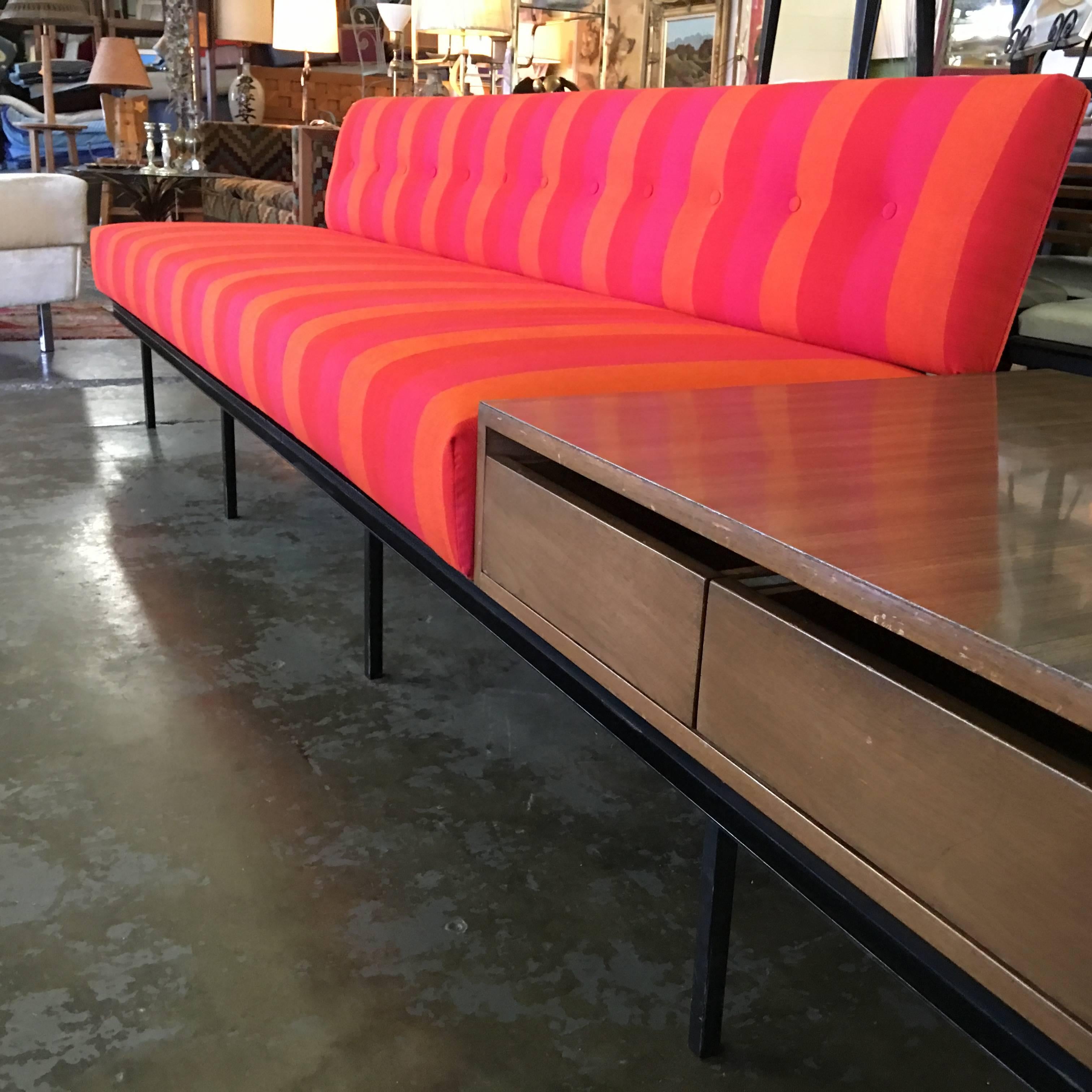 This is a vintage 1950s original Florence Knoll sofa. It is an early design for the company. It is comprised of an iron base with seat and back attached, and includes floating two-drawer end table, all in one! It is 10 feet long. Done in period