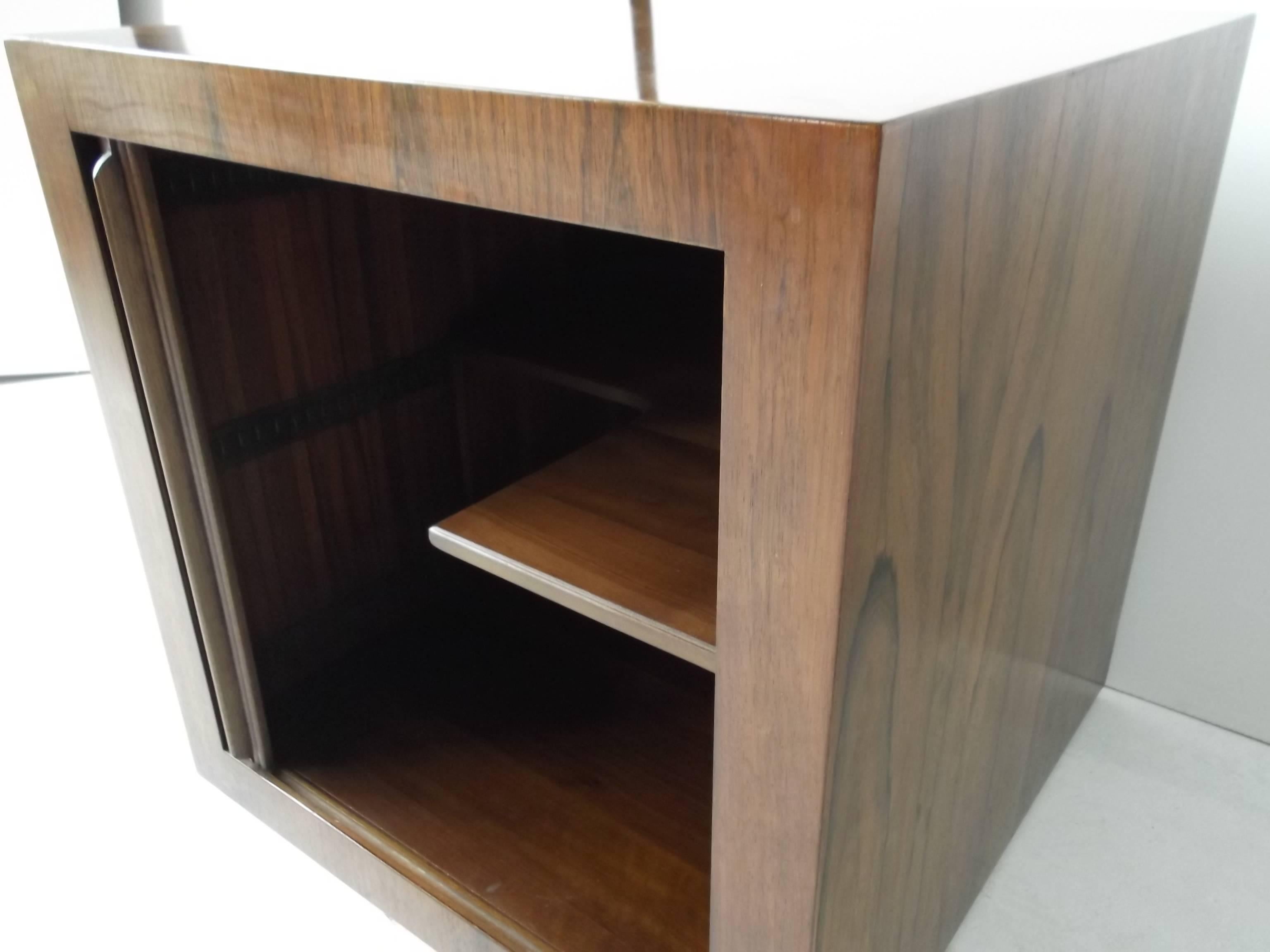 Gorgeous figural rosewood, finished to all sides, rolling barcart cube table. Features tambour door, internal cut-out shelf for bottle storage.
