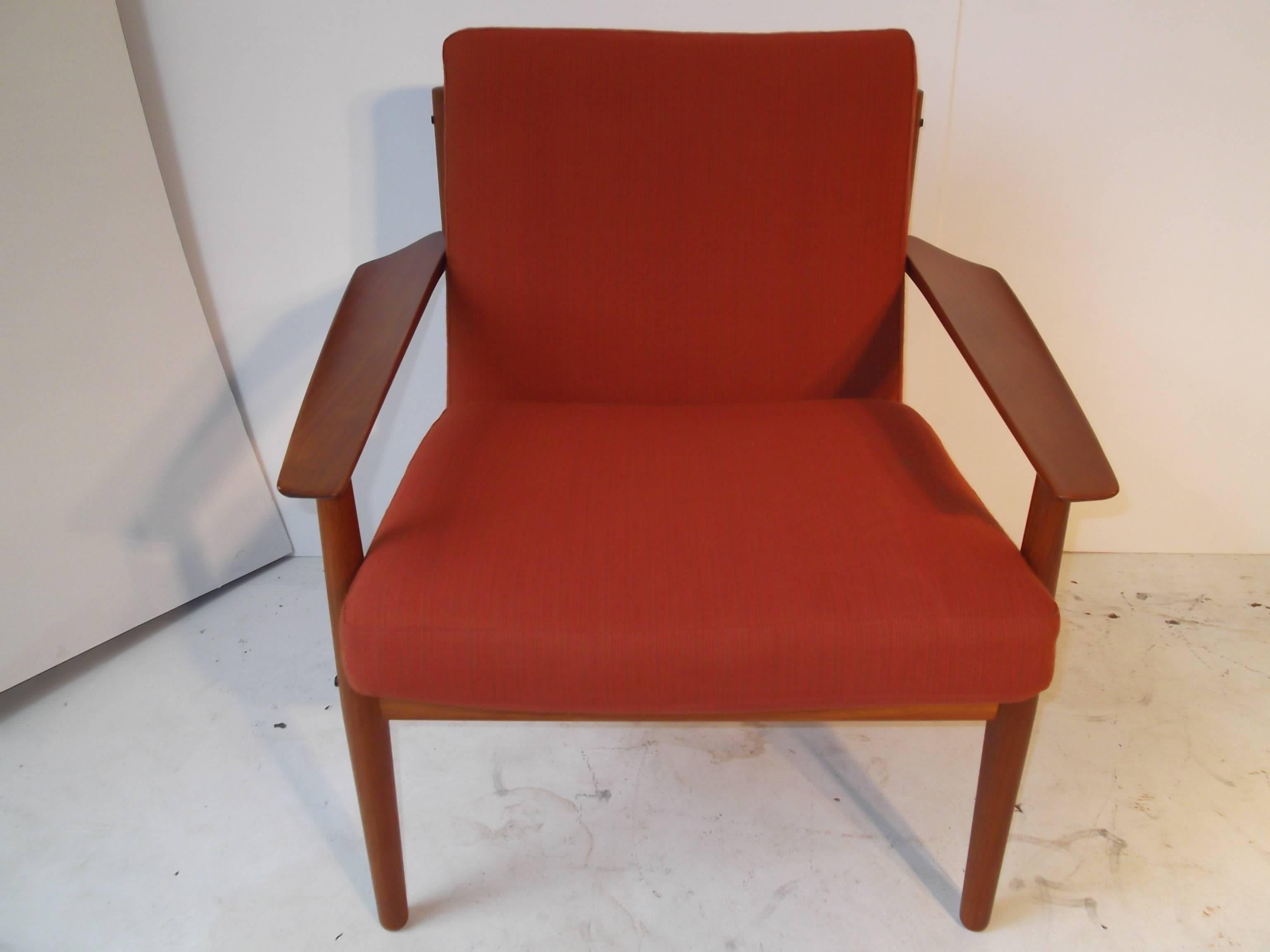 Wonderful design solid teak, Danish modern armchair, designed by Arne Vodder for Glostrup Mobelfabrik. It is in original burnt orange woven wool that has been newly refoamed. The arms are concave front to back more pronounced at the winged out