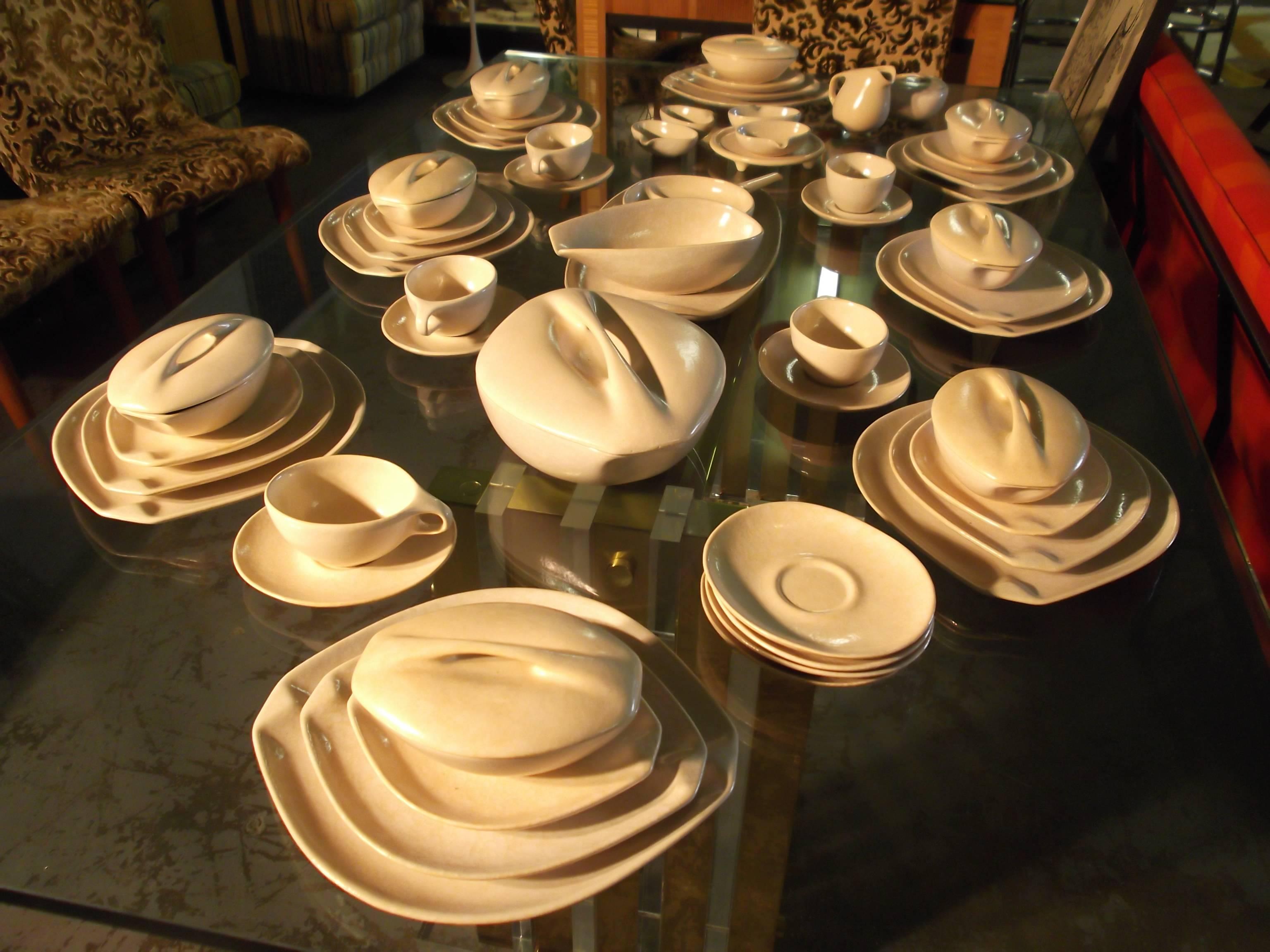 This is a fantastic full set of Ben Seibel Roseville Raymor dinnerware. There are 56 pcs. in all. There are eight-place settings with few missing pieces. It is in the off-white color with a mottled finish. The forms are all elongated! The dinner