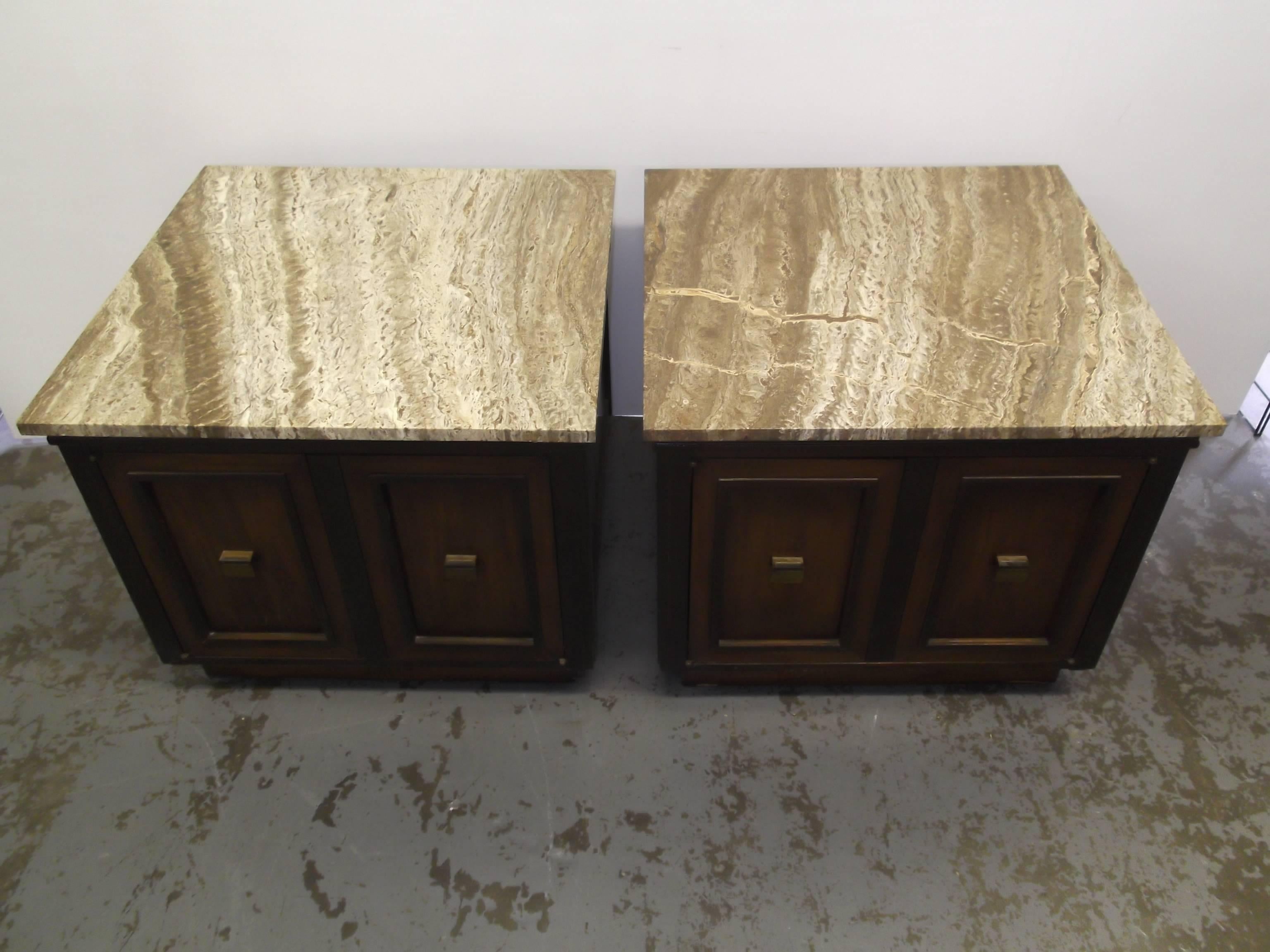 This is a beautiful pair of large low end tables, in the manner of Harvey Probber. They feature doors to the front with a shelf inside. They have contrasting dark, and lighter finishes. There are brass handles. The tops are figural Travertine that