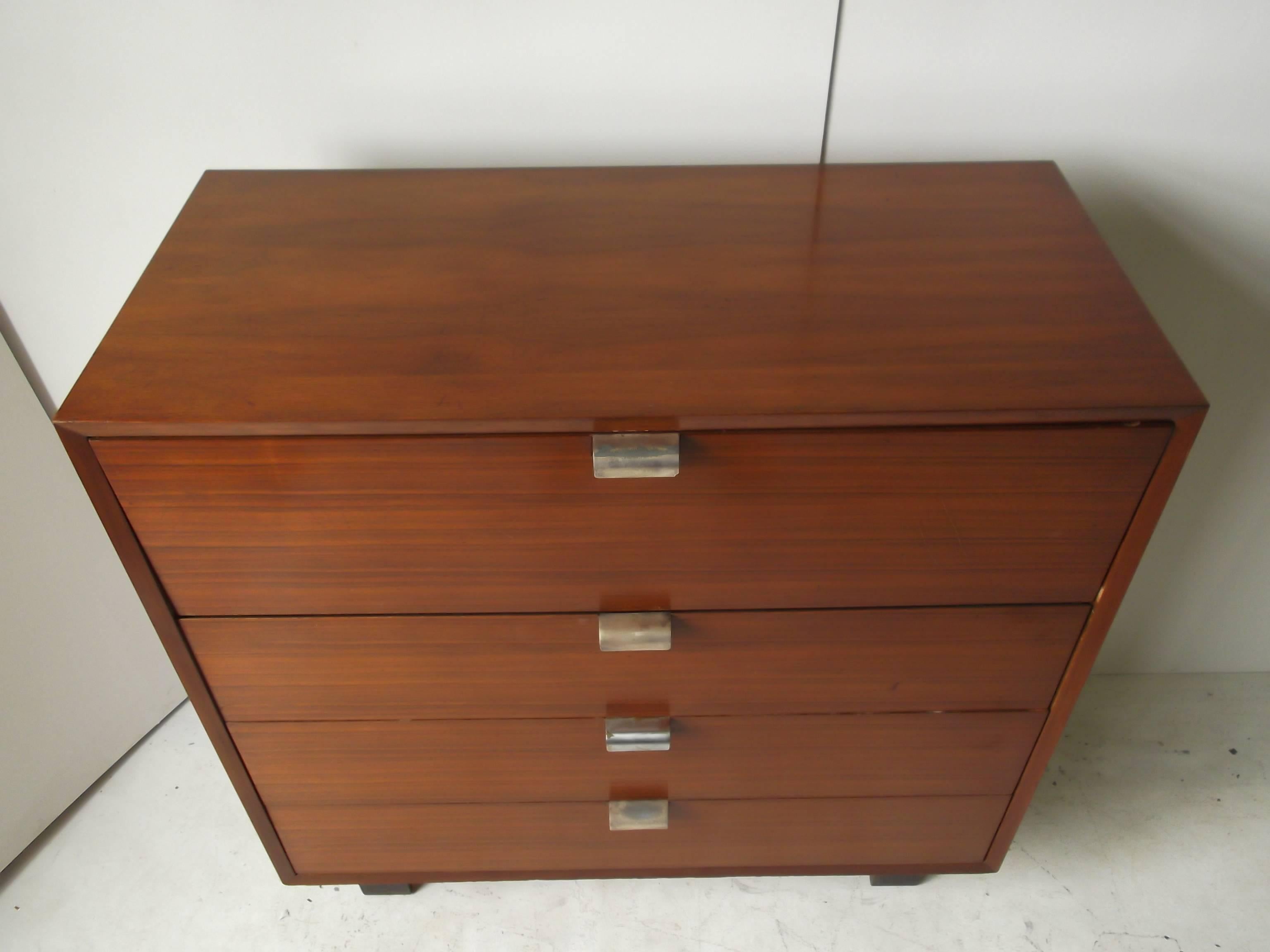 This is a fantastic grain walnut chest of drawers for Herman Miller, by George Nelson. It is from the basic cabinet series, BCS. It features a top pull-out, drop-front desk, with cubby holes to inside. It has a 1950s. Signed George Nelson foil