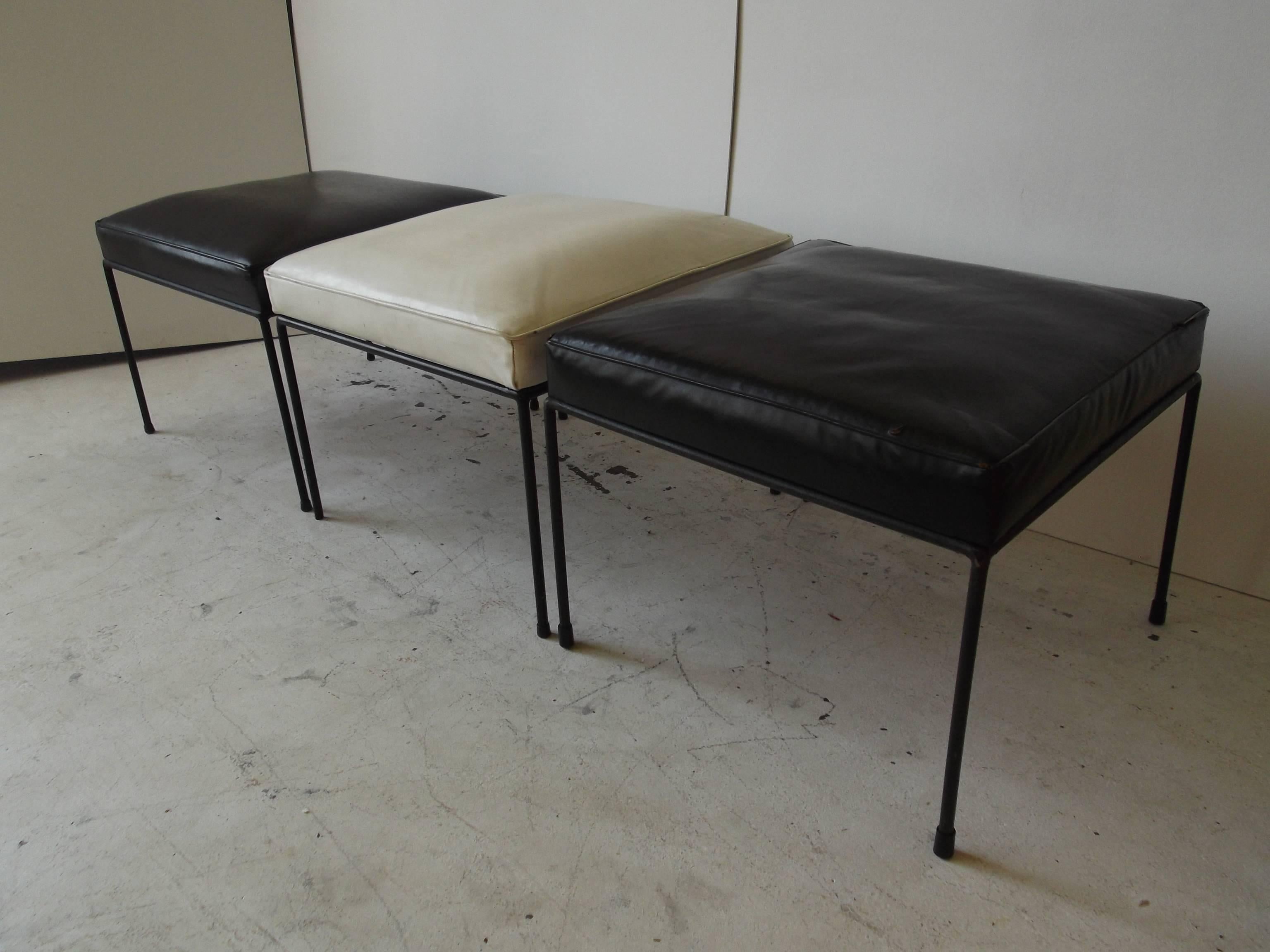 This is a set of three original Paul McCobb Iron stools with vinyl seating surfaces. They are a set that has always been together. One black is a little more shiny than the other, and shows wear to edges. These are vintage from the 1950s.