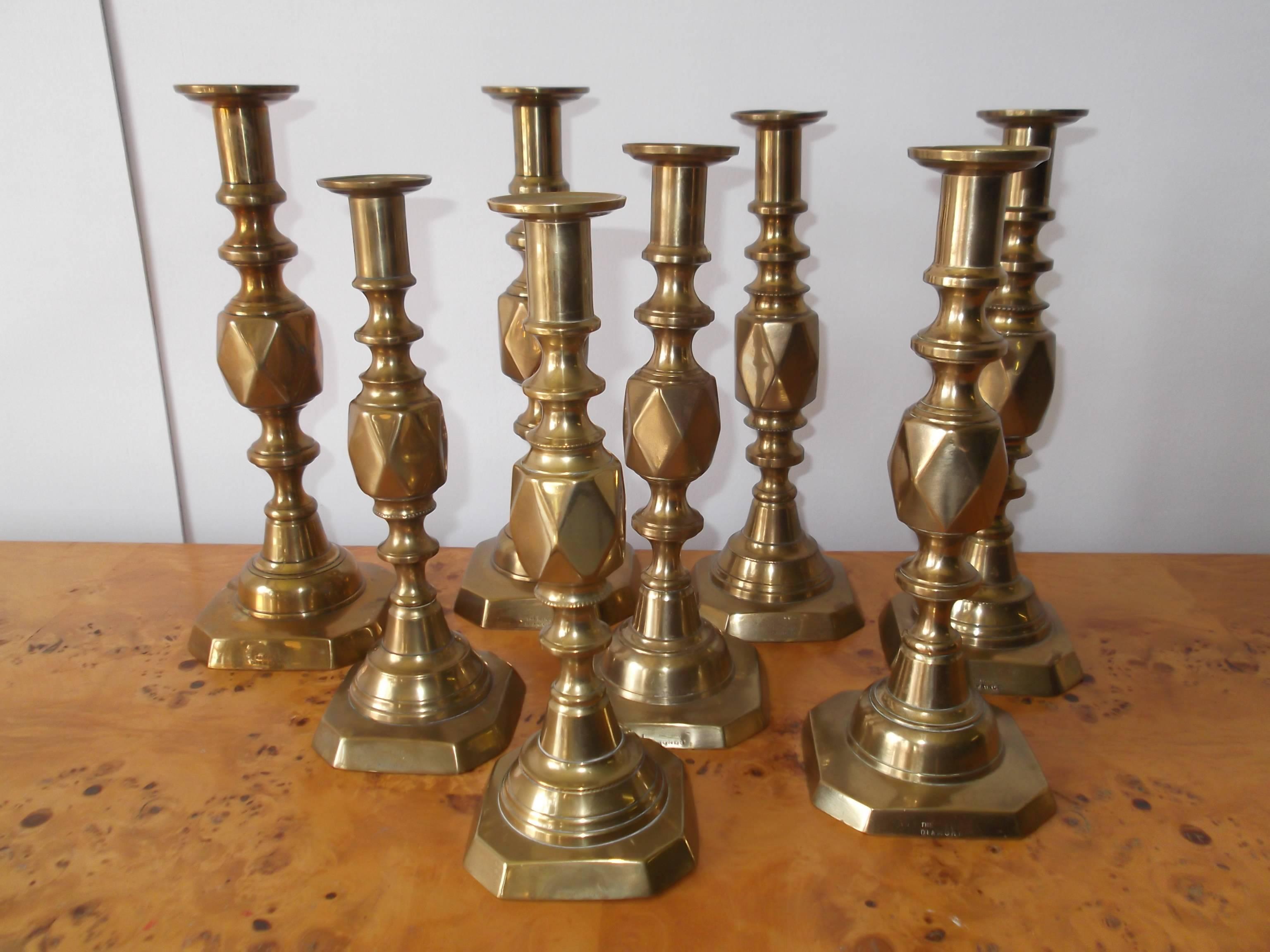 Set of 8! This is a wonderful collection of Antique Brass Push-Up candlesticks. They are from the 1890s celebrating the Queen Victoria Jubilee. The collection is sold together. The pieces are all signed to bases. Included are, 