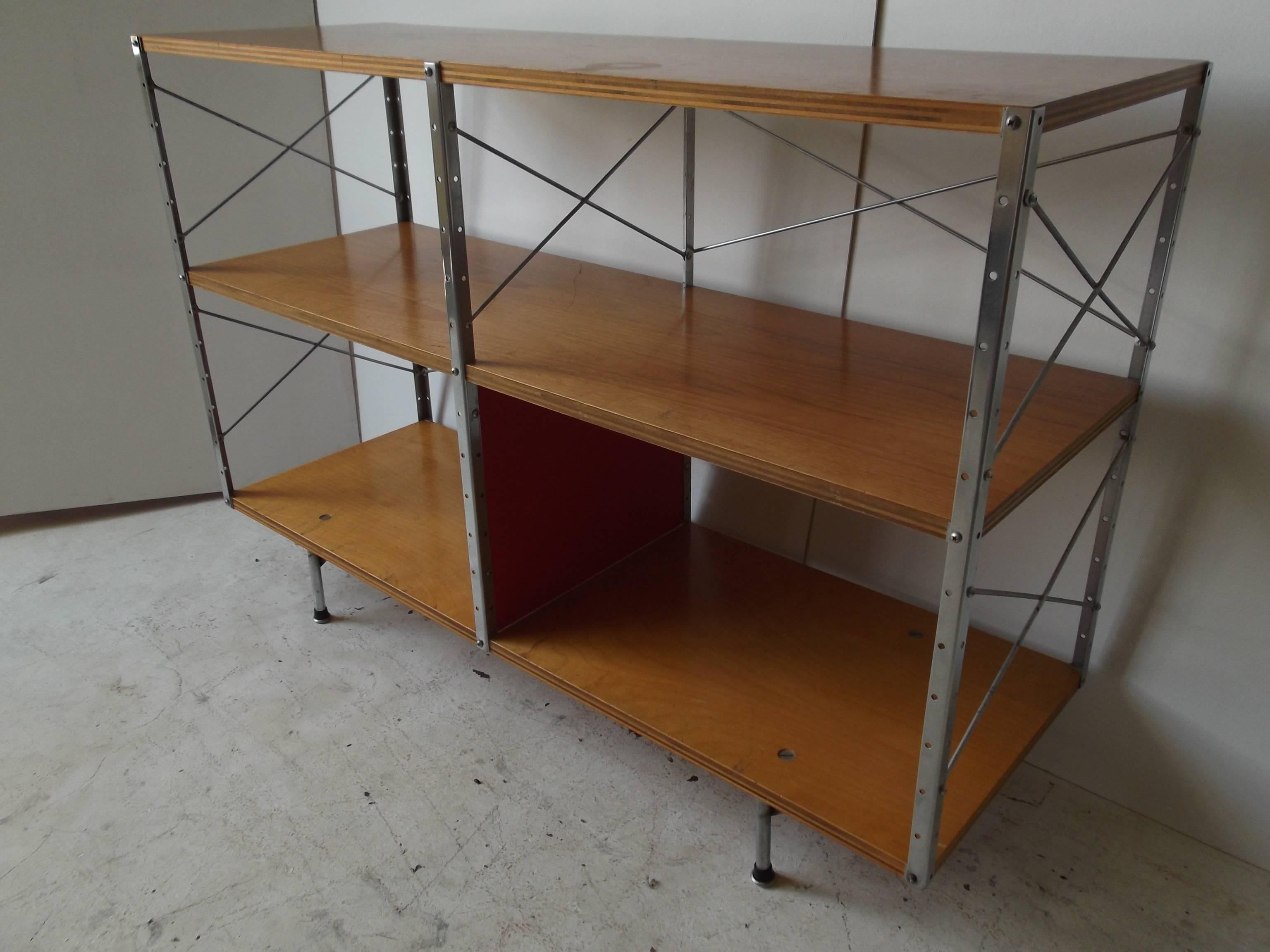 This is a great example of an original Charles Eames Storage Unit for Herman Miller. It has 2nd series feet. There is one bright red panel to the bottom center. The top and middle shelves are beautiful veneer walnut on plywood, with the bottom in