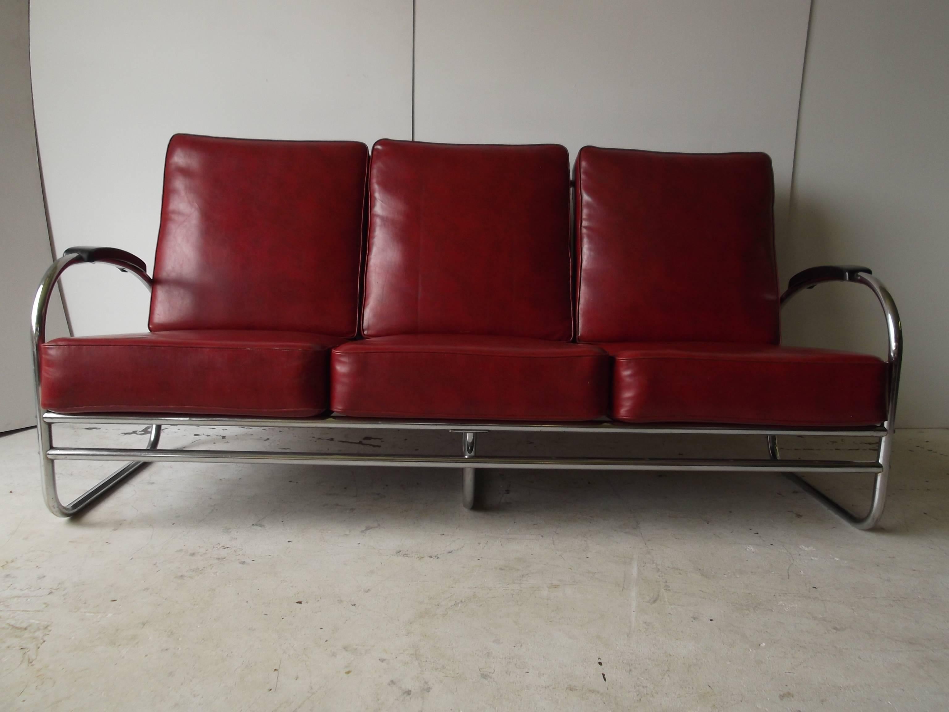 This is a very nice example of a period Art Deco design sofa for Royal Metal, see label. It retains its Original Vinyl cushions in a red color. There are no tears to fabric. The bakelite armrests are not chipped! The chrome is showing signs of rust
