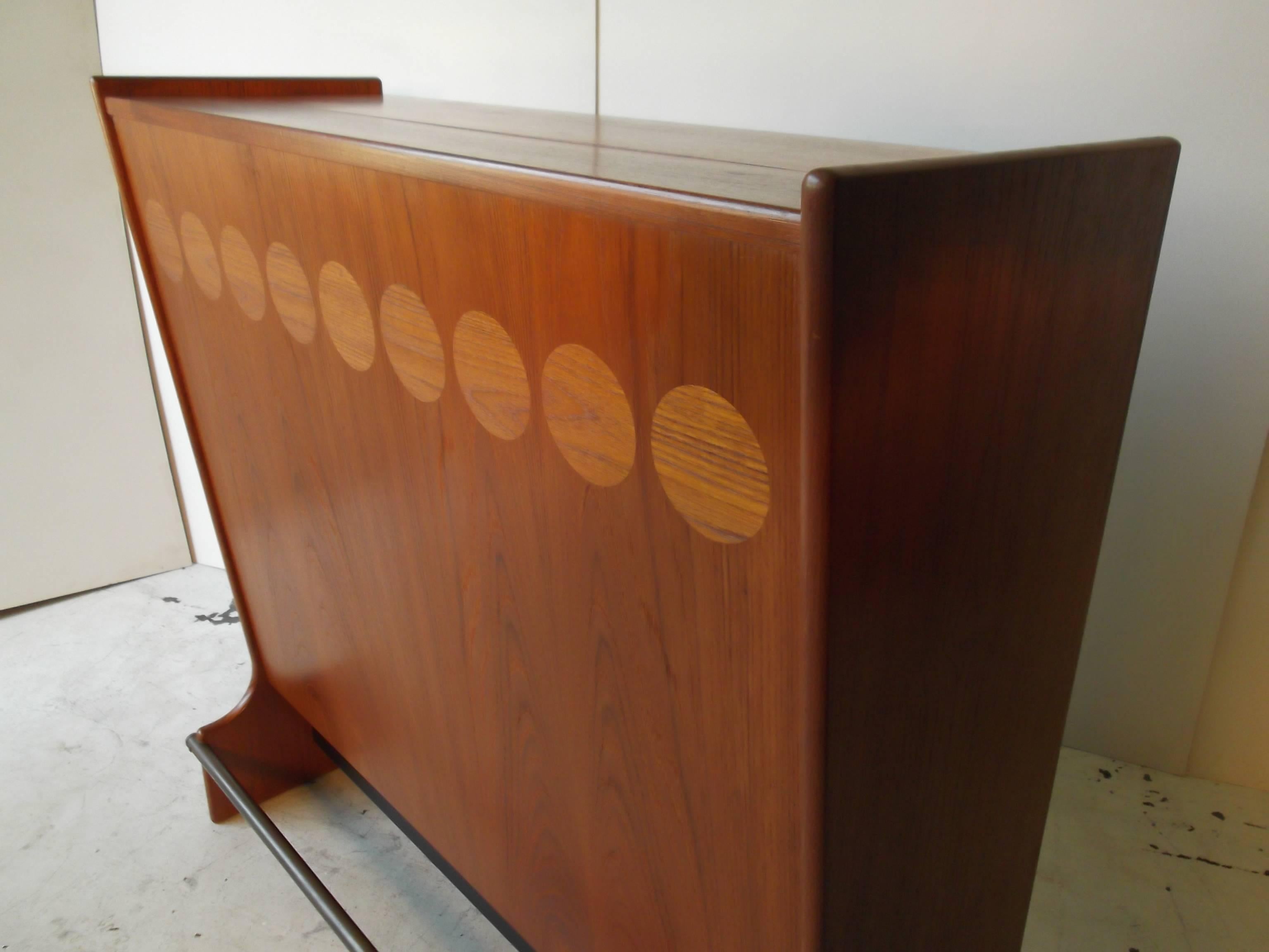 This bar is amazing, with inlaid contrasting grain circles to the front and the back too. It is freestanding. It retains orig. Danish Labels, with Johannes Anderson, for Skaaning Mobler. There is a brass footrest across front. This piece is very