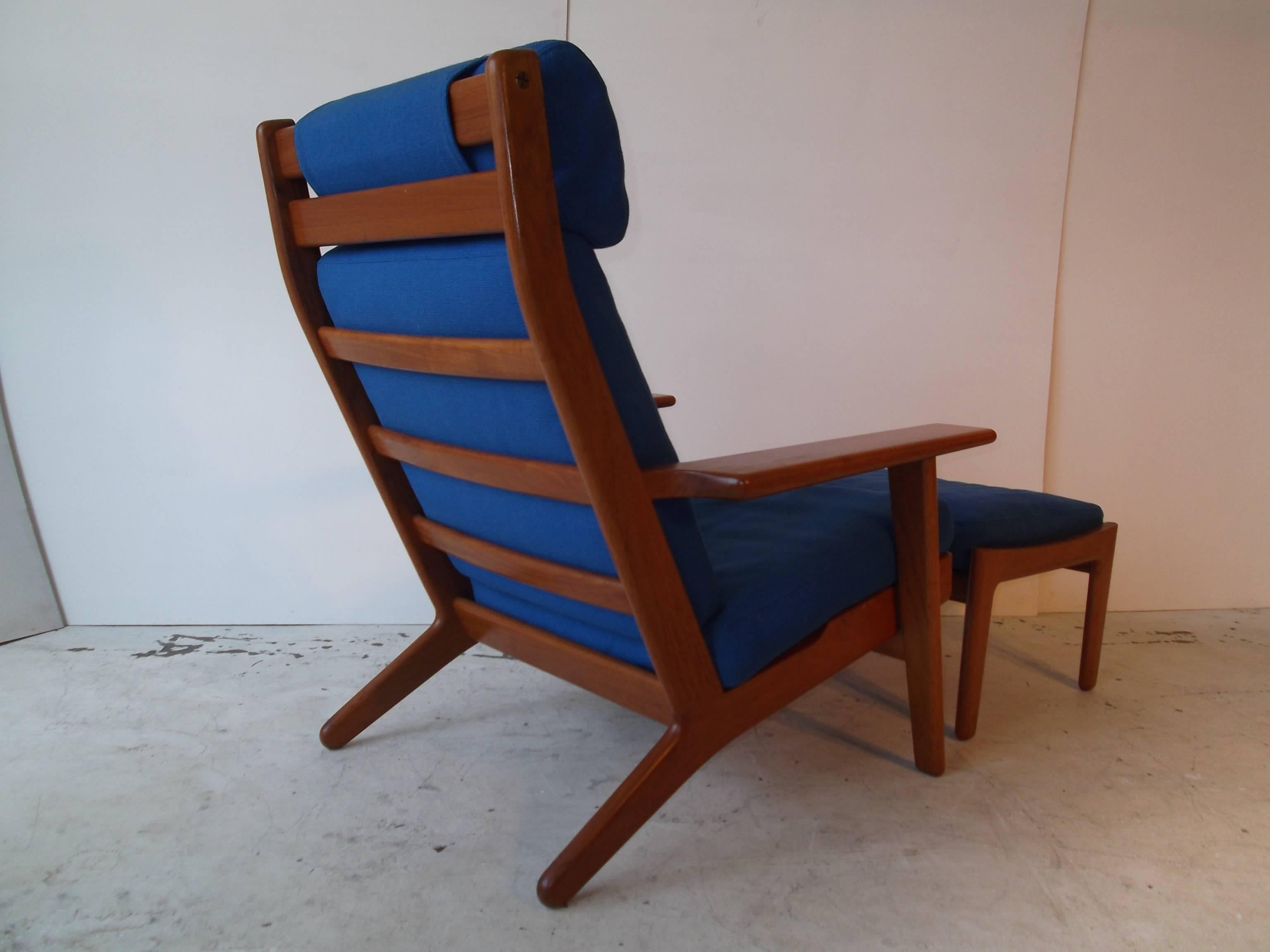 This is a beautiful and clean original Hans Wegner high back lounge chair with its original footrest ottoman. They are out of one owner loving home, in their Orig. Blue wool fabric. Both pieces are solid darker teak. They are vintage from circa