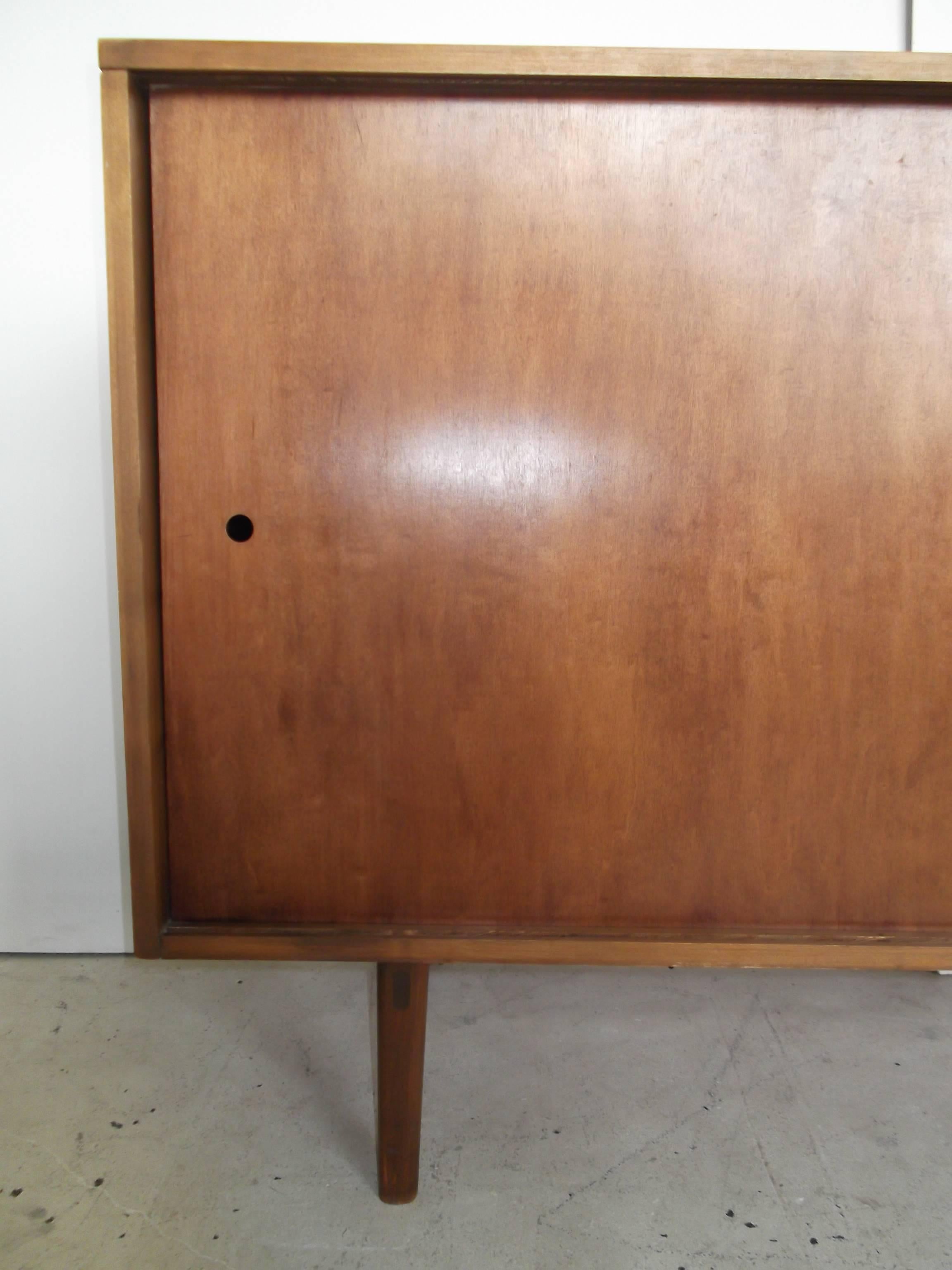 This is a great scale piece by Paul McCobb for Winchendon. It is from the Planner Group Line of the 1950s. It is a credenza or sideboard, and could be used anywhere in a house. I has sliding doors that reveal three drawers to right, and one on left