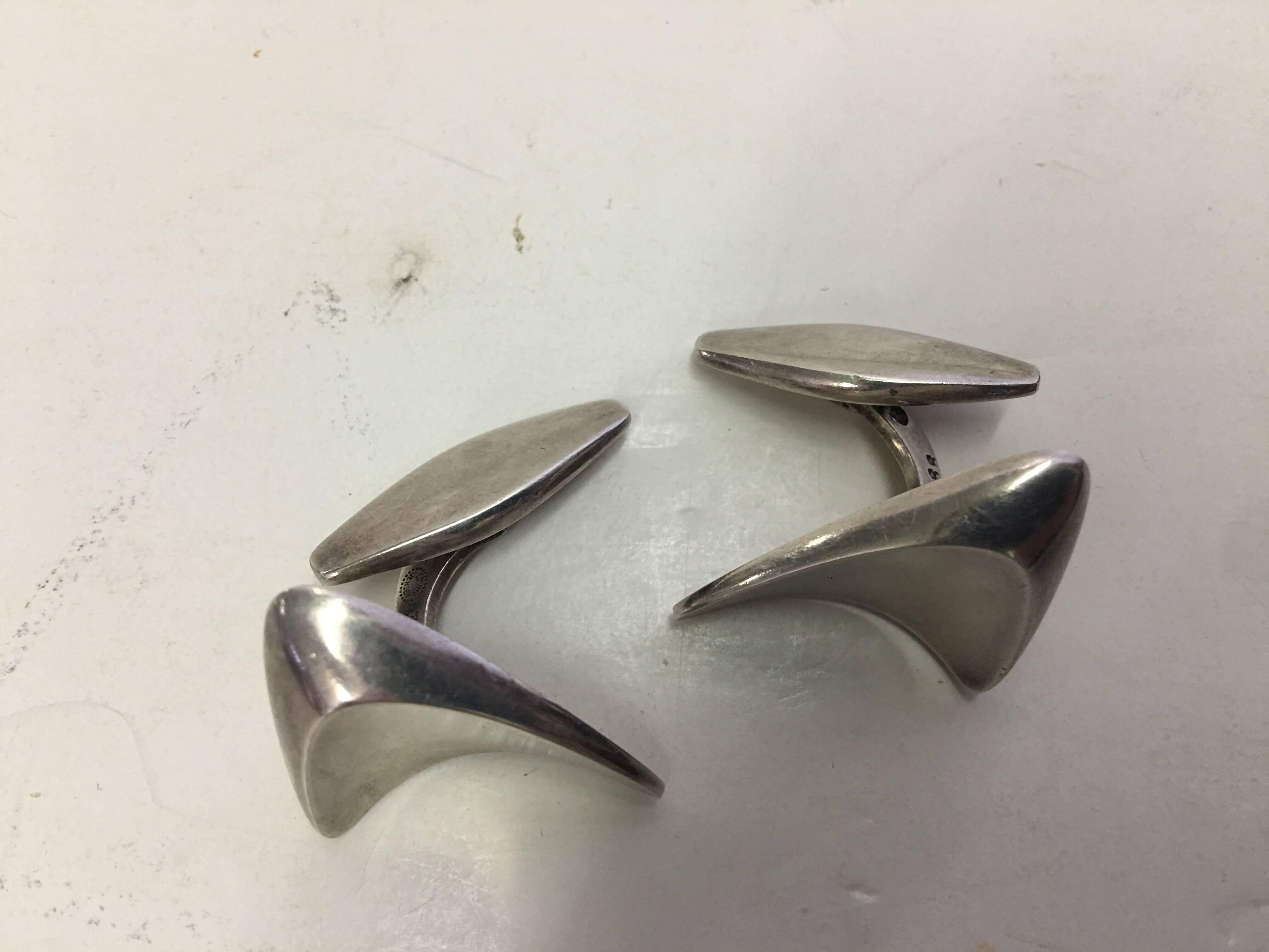 These impressive sterling silver cufflinks have a modernist design to them, in a biomorphic boomerang form. They are a Henning Koppel original design from circa 1960. Signed Georg Jensen.