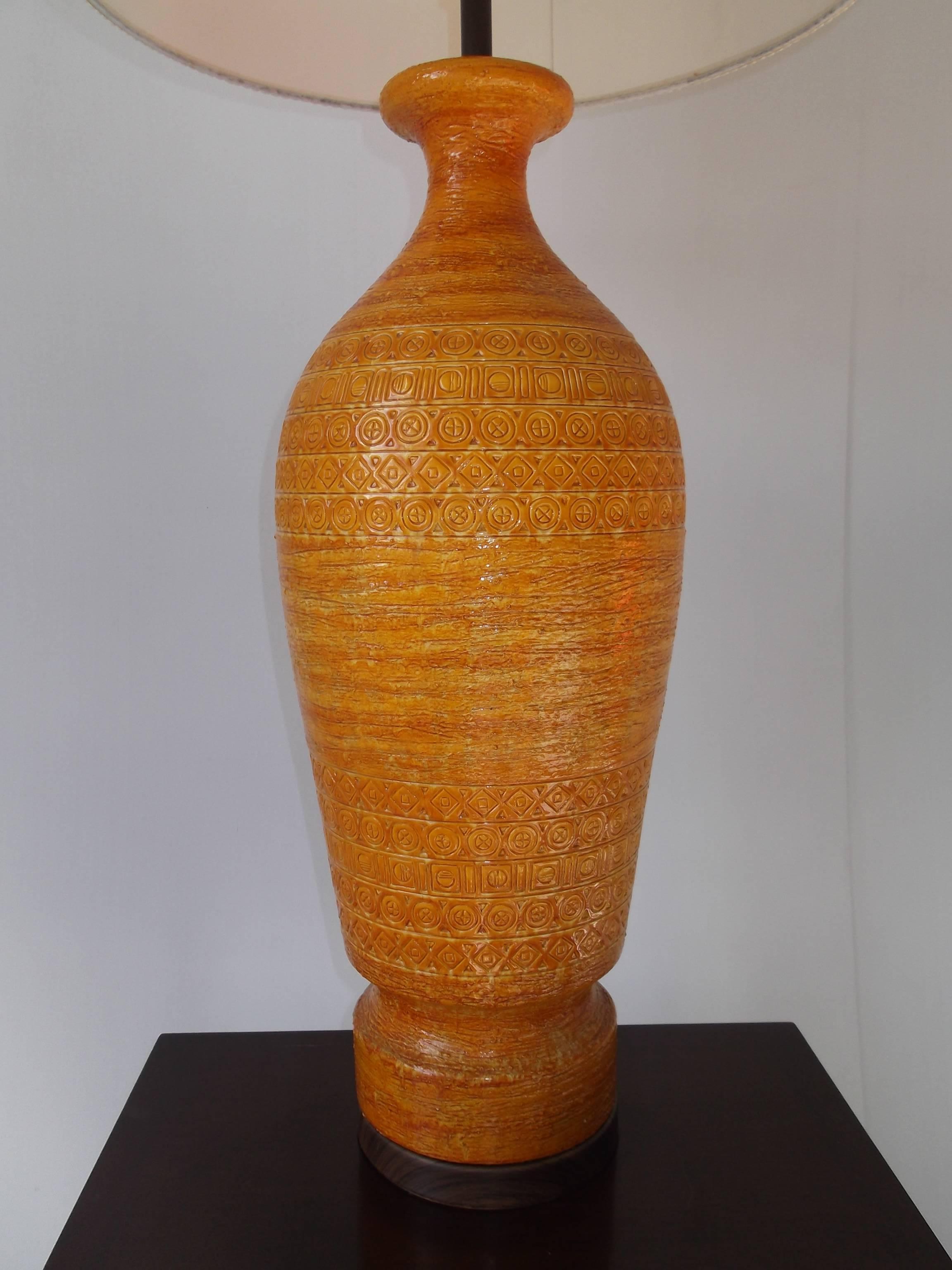 Nice tall proportion. Orig. clean shade. This Bitossi Italian pottery lamp features a bright orange glaze, with diamonds, circles, and squares to the body. It really; is wonderful! It is vintage from the 1950s era. It measures 22.5