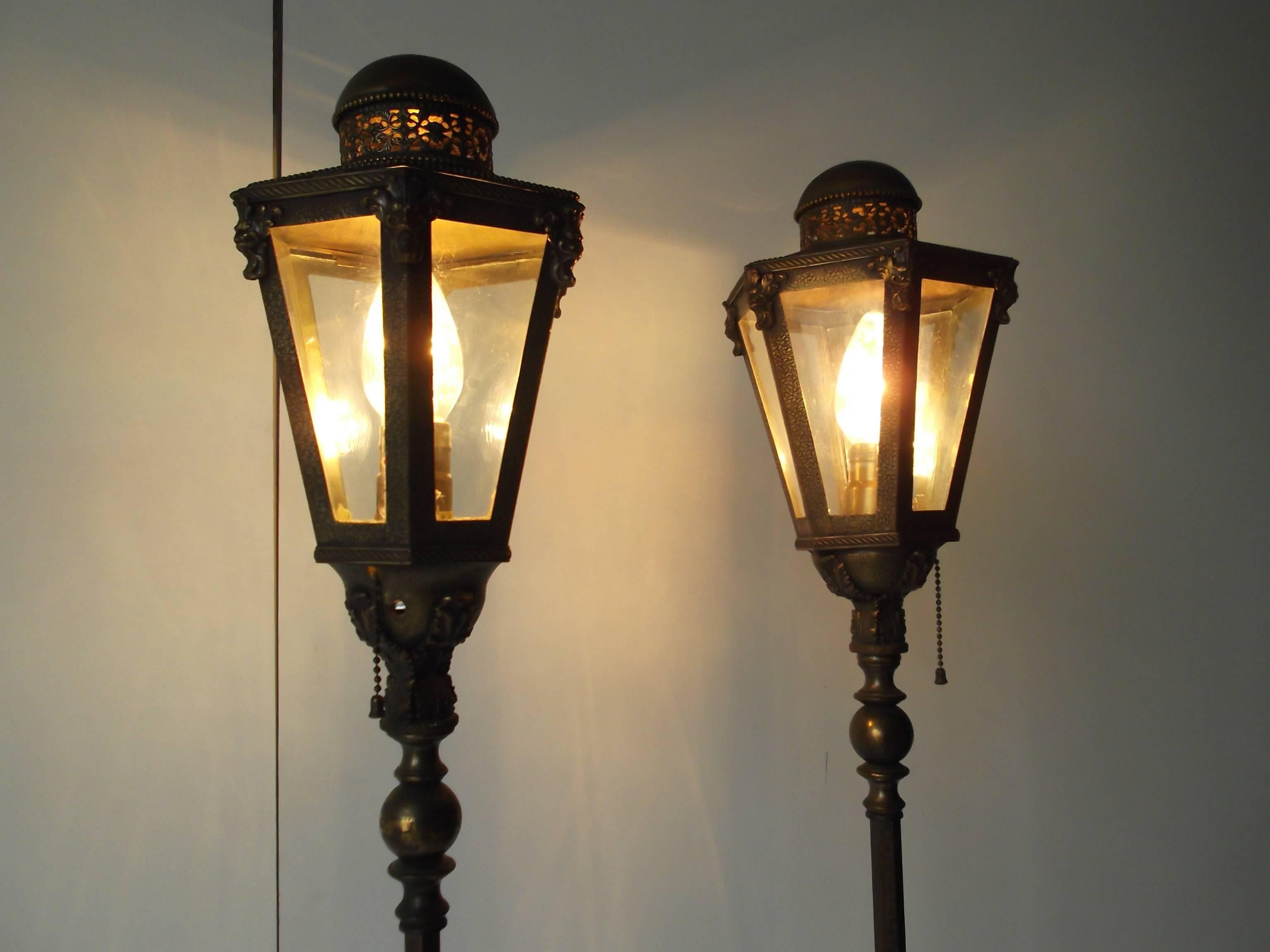 Fantastic pair of antique floor lamps. They have six-sided lanterns to the tops to match their hexagon Onyx and ornate brass bases below. The bases have mounted red and turquoise stones. Wow! They tower at 68