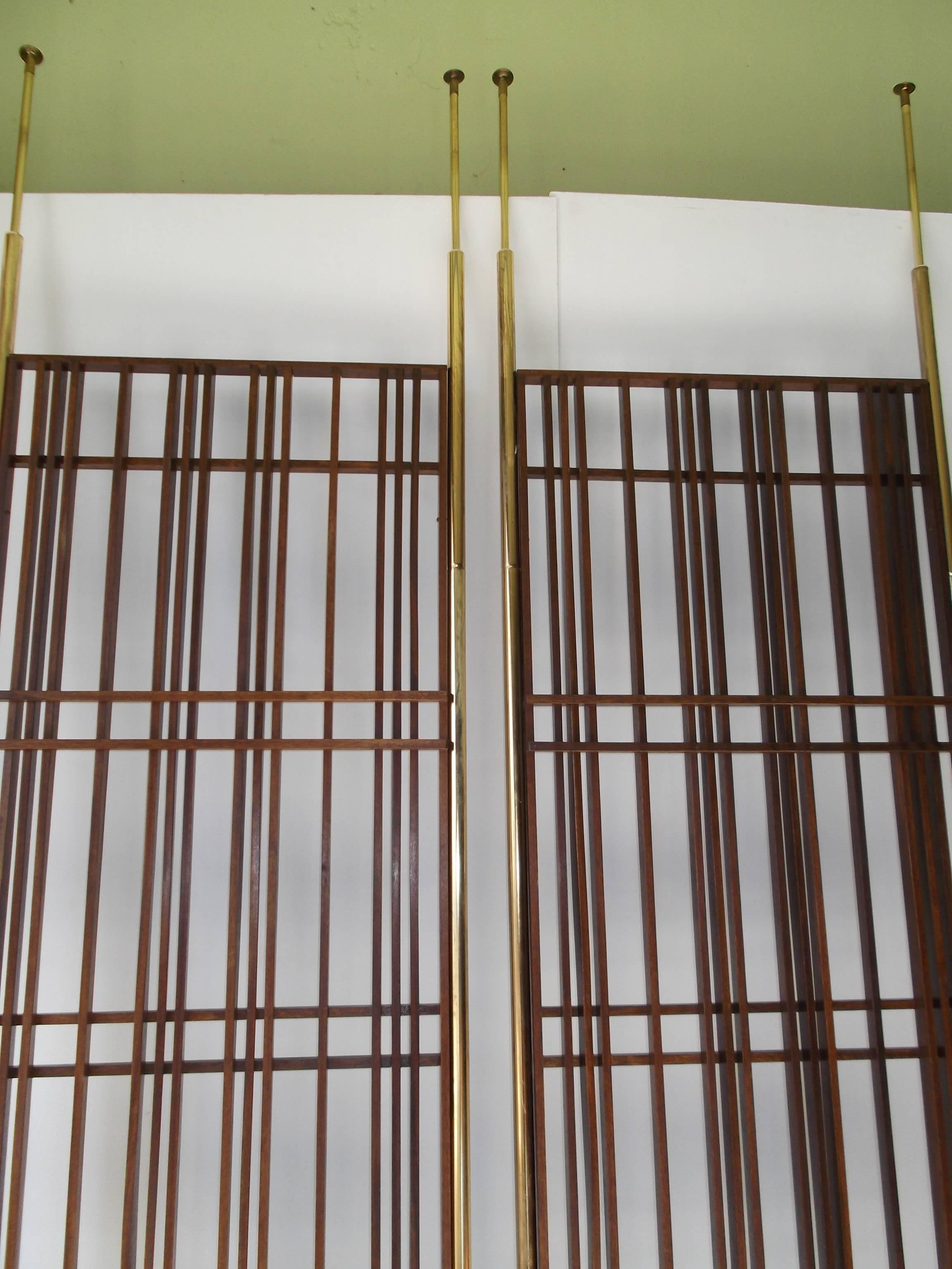 This is a pair of fantastic room dividers from the Mid-Century. They are made from stained mahogany slats mortised together in a modernist grid. They are open air, not too private. They are floor to ceiling tension mounted to fit 8 foot ceilings.