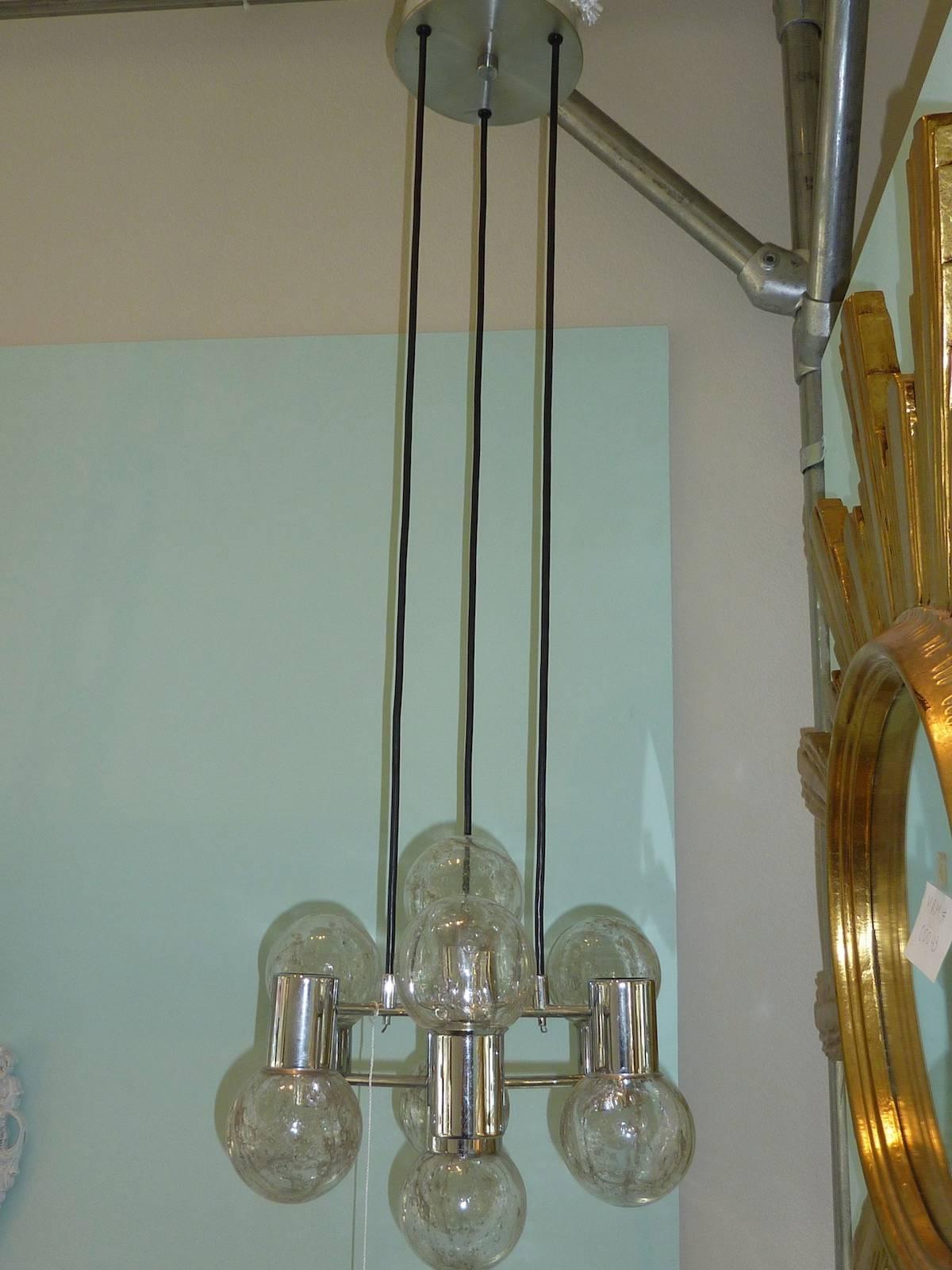 Mid-Century Modern chrome and glass ball pendant light fixture. The sculptural fixture has sockets which project both up and down, giving good illumination. The balls suspend from original cording and canopy.