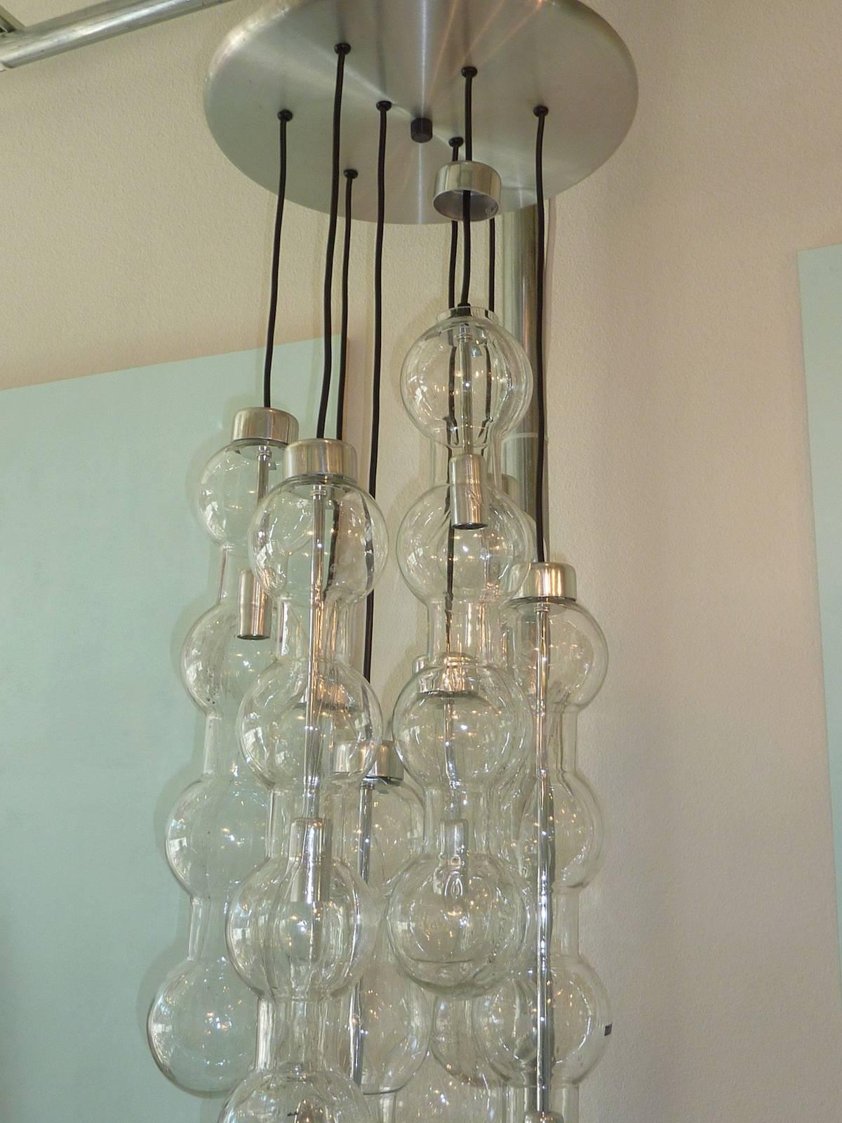 A 1960s Doria modern glass chandelier with eight cascading bubble strands. Strands feature original Doria brand stickers. Discovered at private sale in Germany. One previous owner. This item will move quickly . It has original vintage Euro wiring.