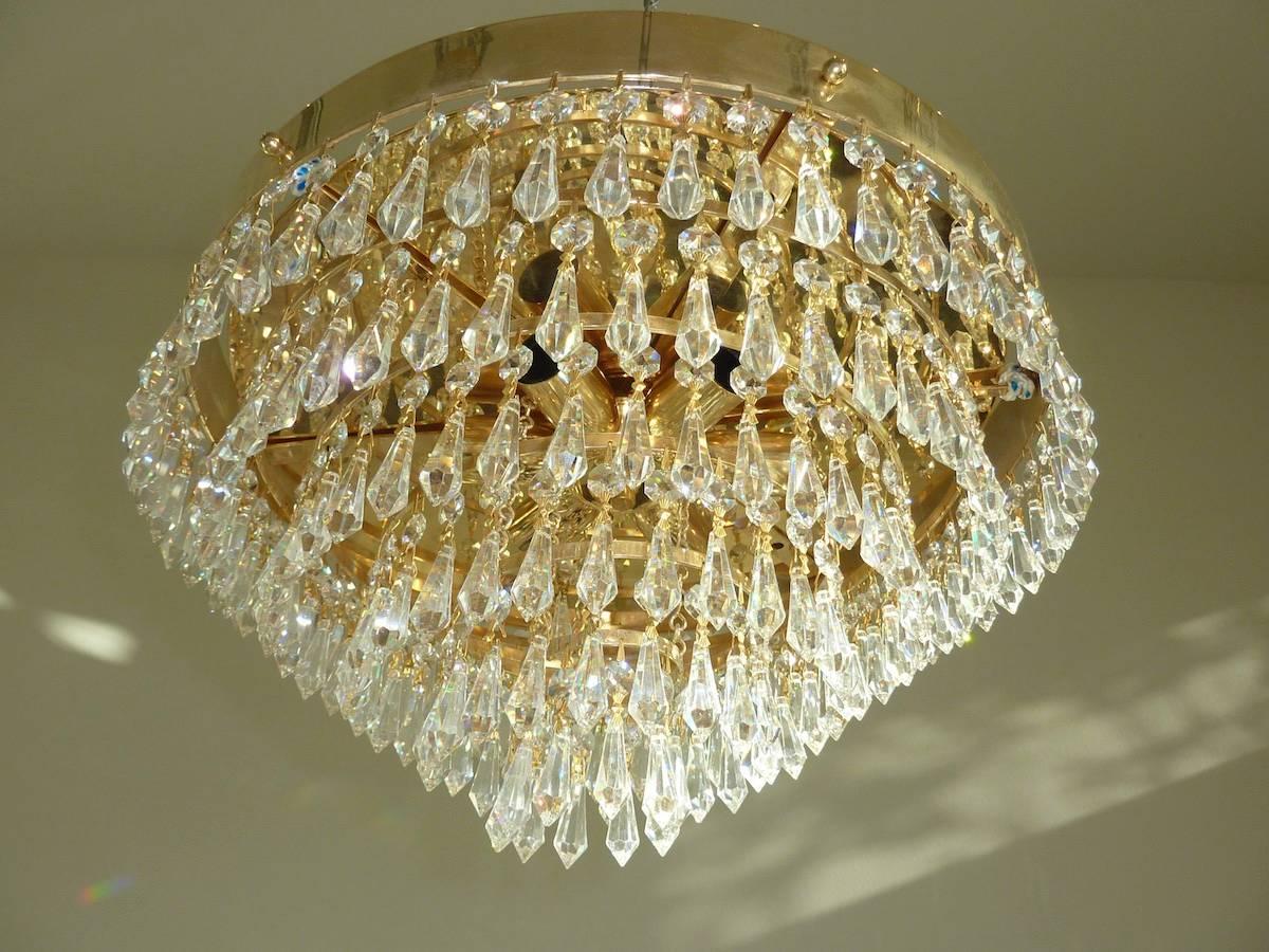 This glamorous Hollywood Regency style chandelier was made by the firm of Dolzauer of Austria in the 1960s. It has beautiful crystals and gold-plated trim.