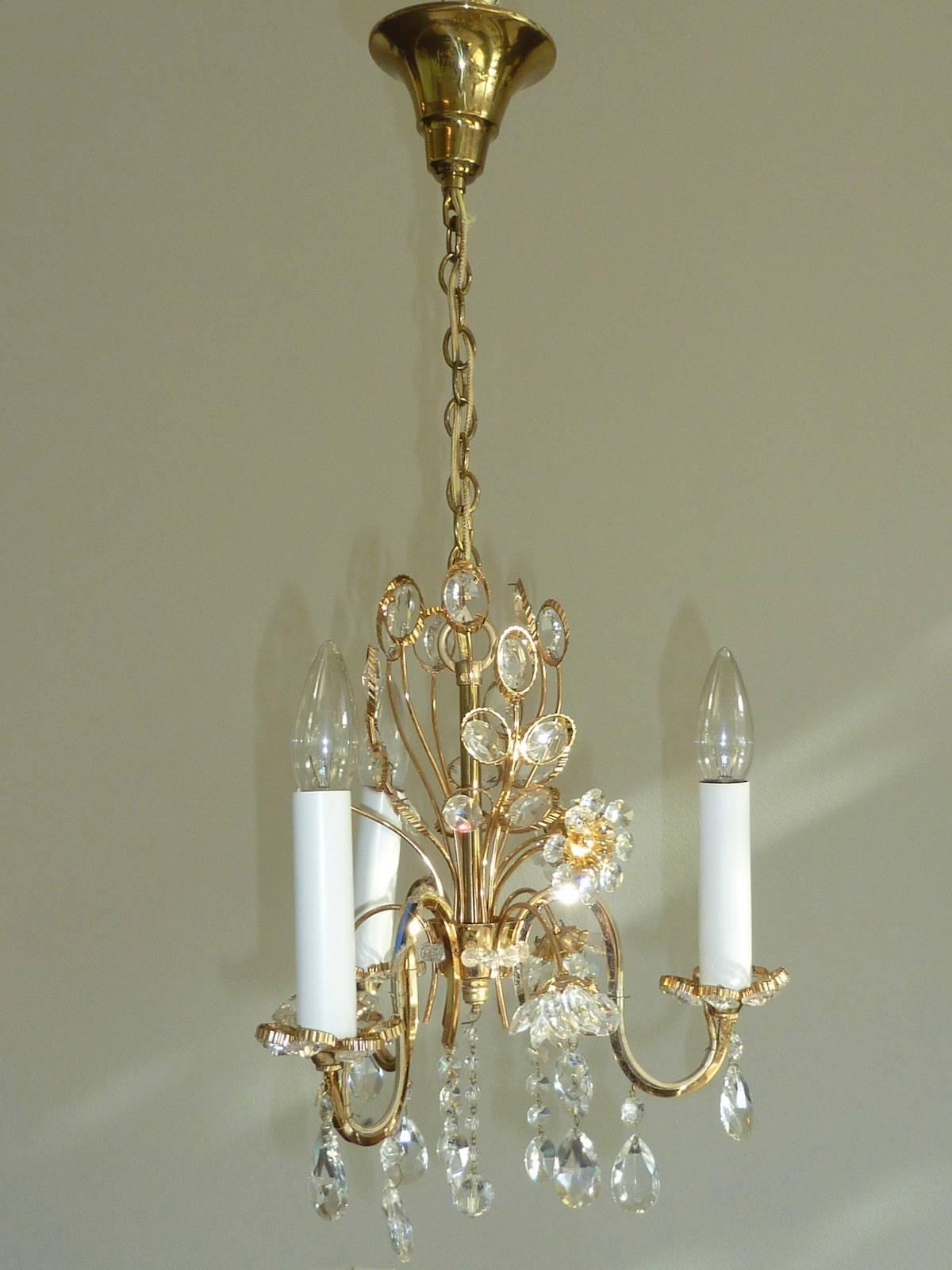 Petite chandelier crystal flowers made by the German company Palwa. The fixture has three European style E14 sockets. It requires three European E14 candelabra bulbs.